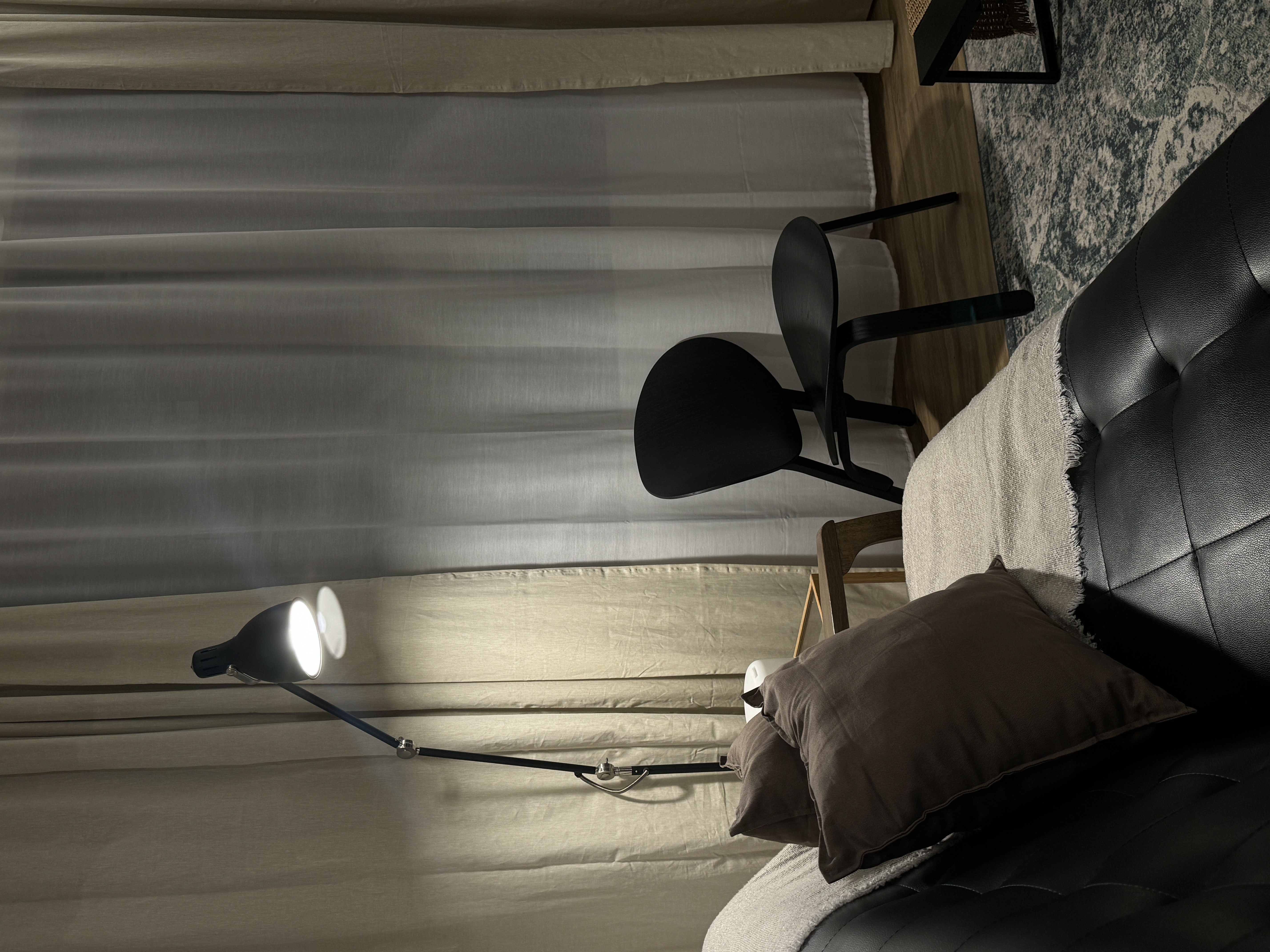 A characterful living room - Modern minimalist living room, cozy seating area, black leather sofa, beige curtains, soft