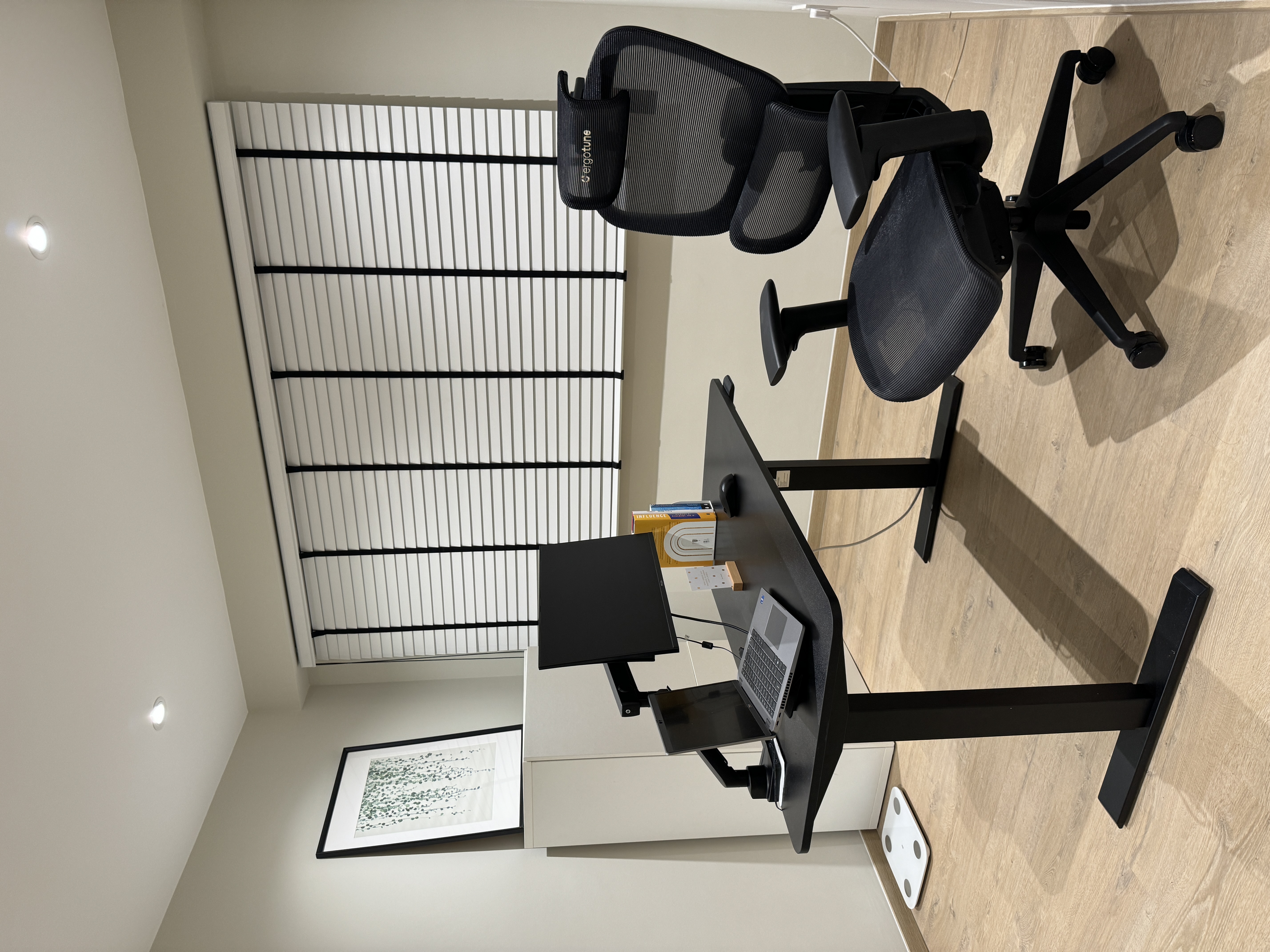 The Art of Remote Work: A Peek into Our Home Workspace - Black office chair, black desk, wooden floor, modern office setup