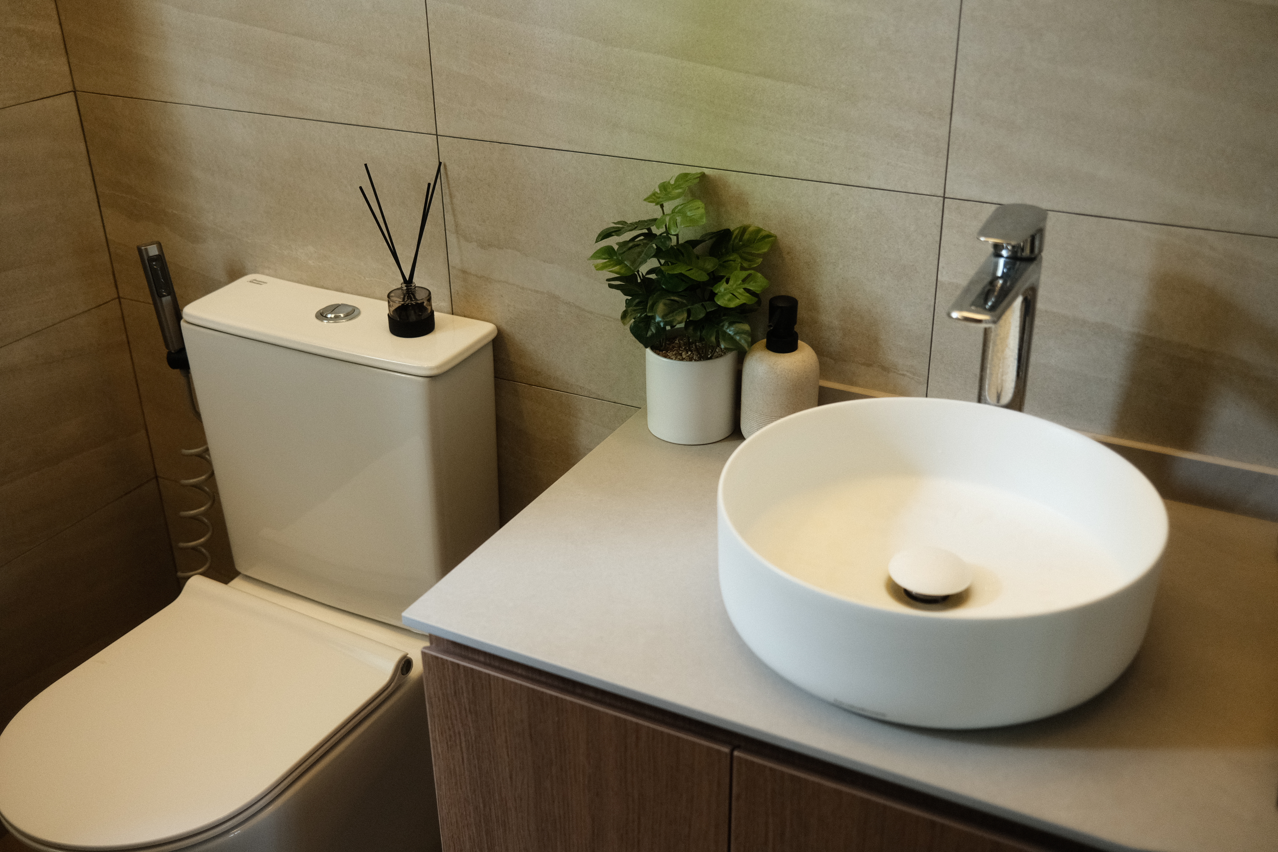 Our only plants in our Japandi Home - Modern bathroom, minimalist design, sleek fixtures, white toilet, beige tiled walls