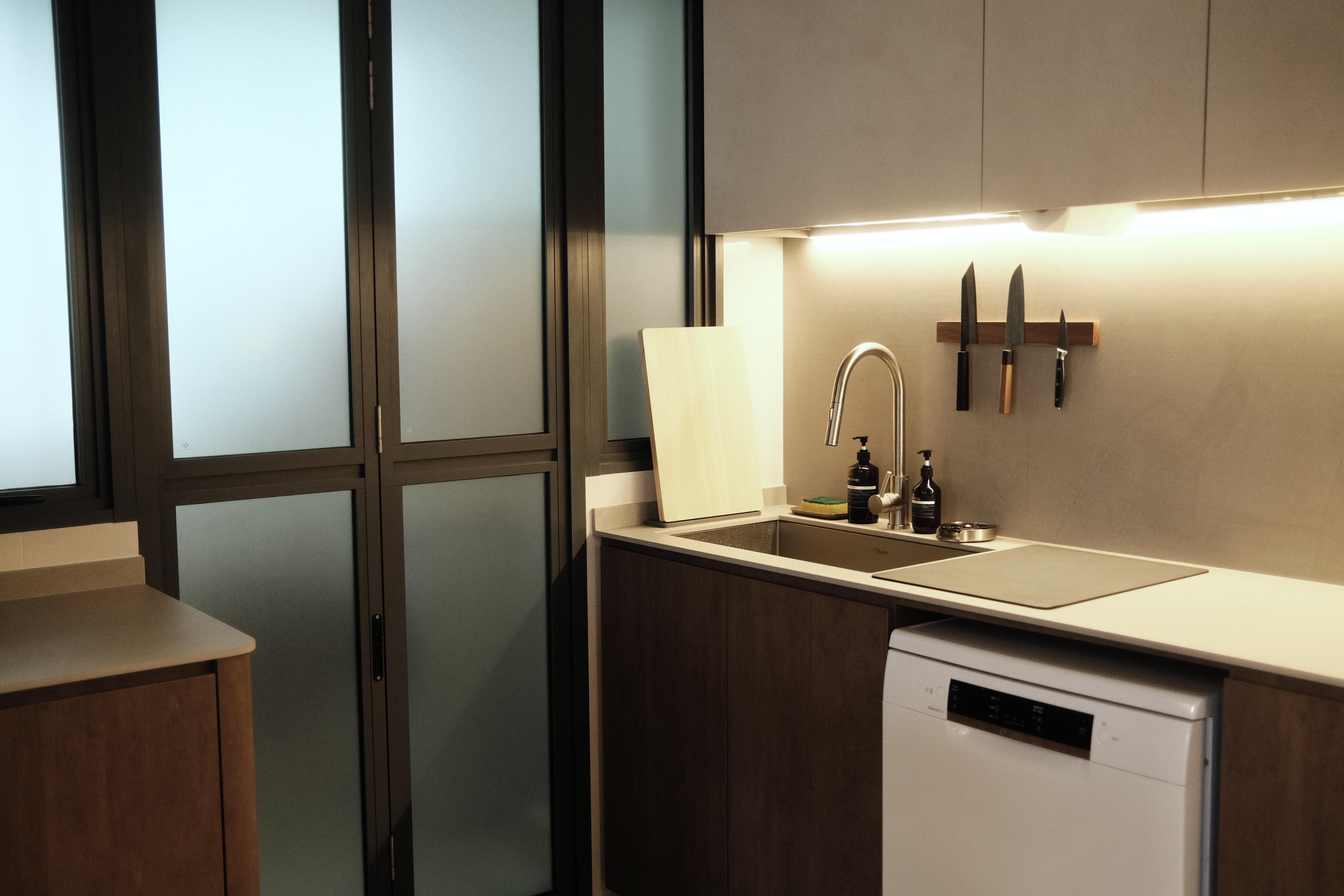 Building the kitchen island of our dreams - Modern kitchen with sleek design, stainless steel sink, white countertop, wooden