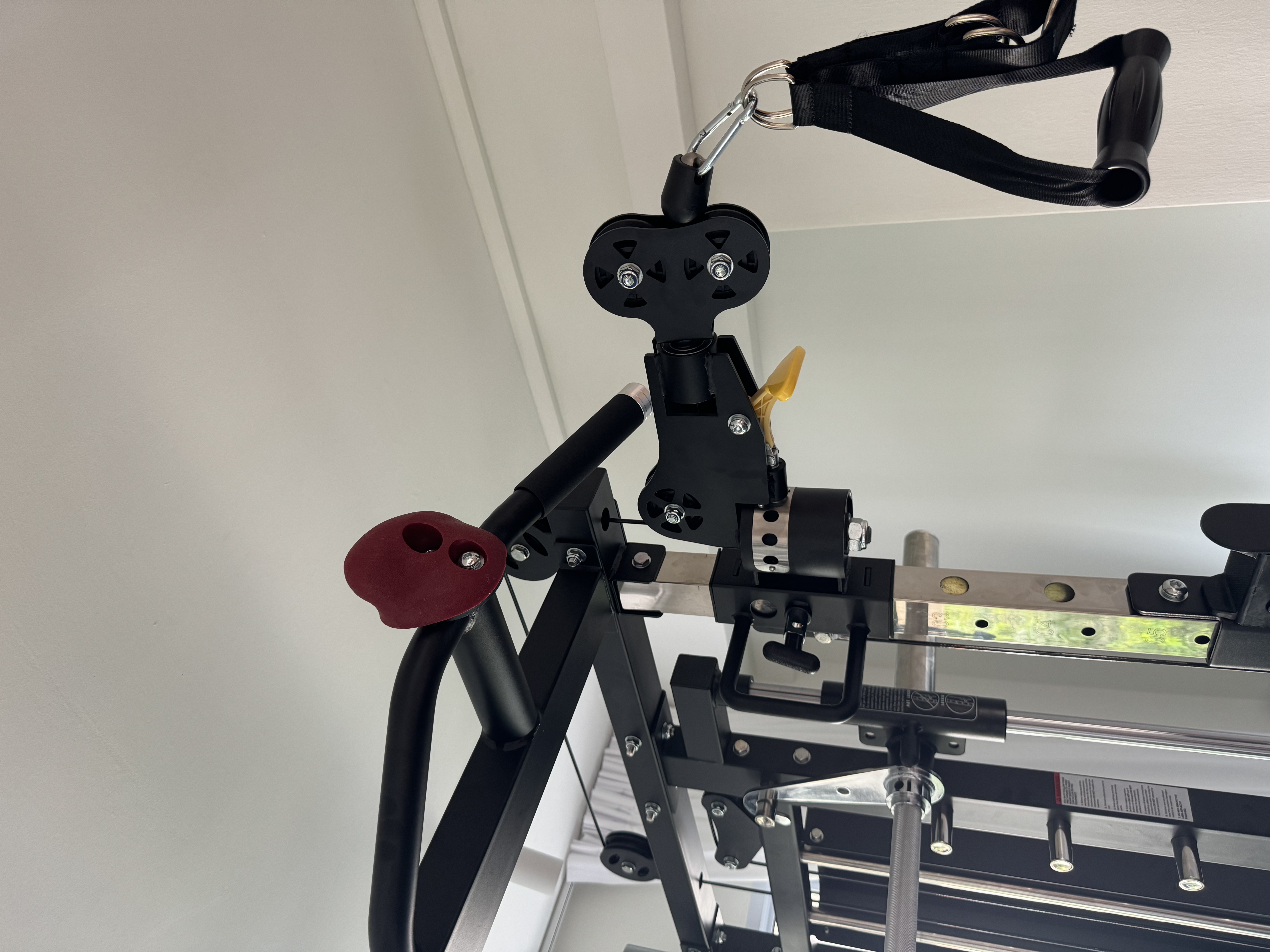 From taukwa to taupok in the GYM ROOM 🏋️ - Black exercise machine with adjustable straps, red handle, yellow grip, metallic