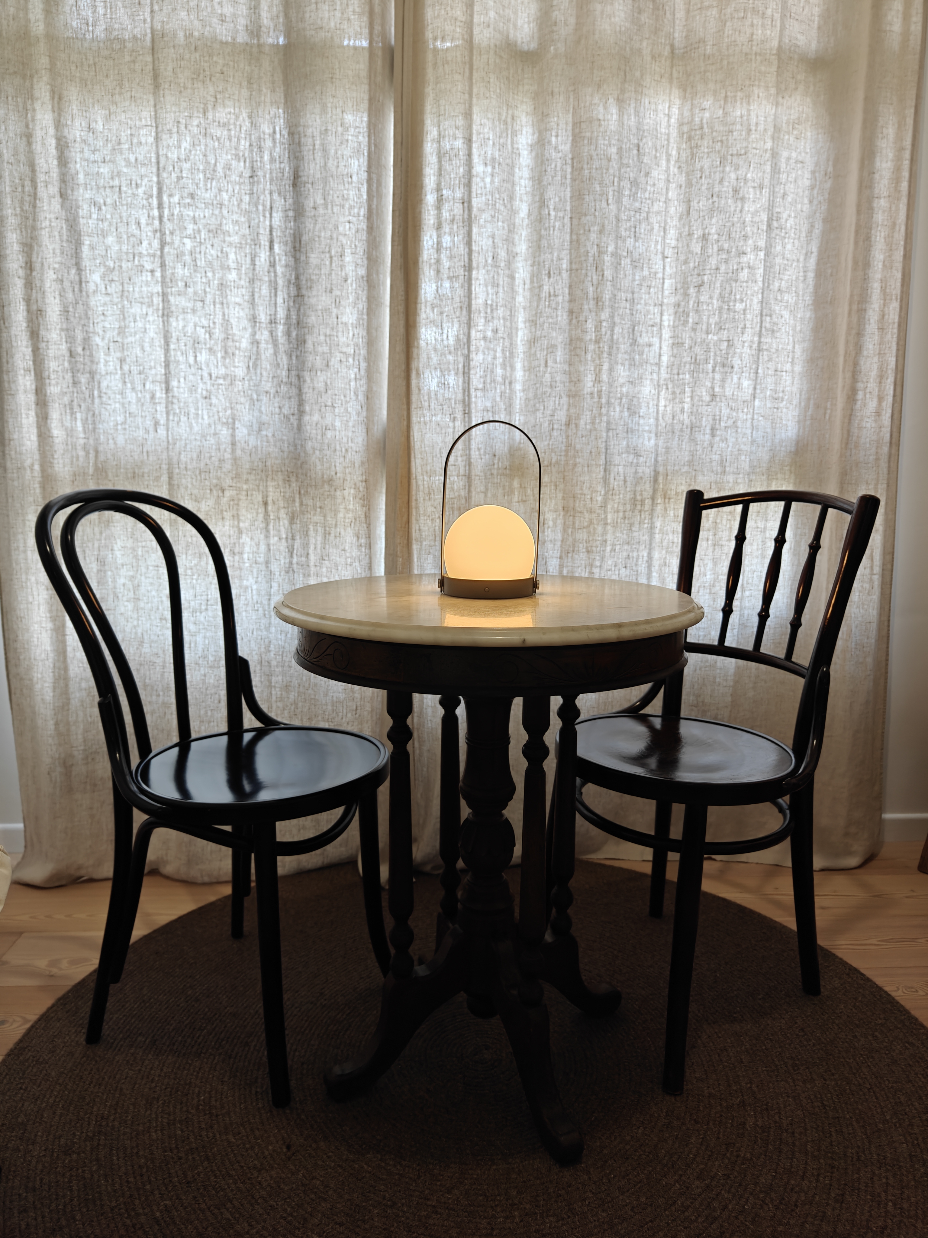 You Light Up My Life! - Cream-colored curtains softly diffuse natural light, creating a serene ambiance. A modern, round