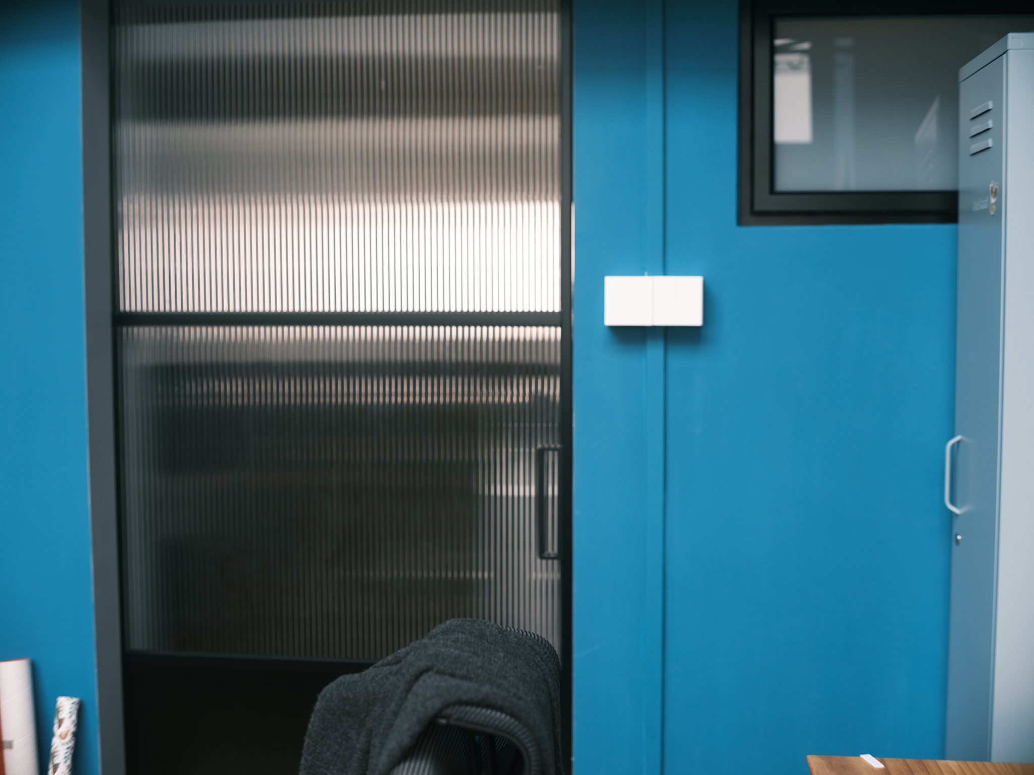 A chic turquoise study with dramatic double-volume windows - Office cubicle, blue wall, metallic door, white switch, gray