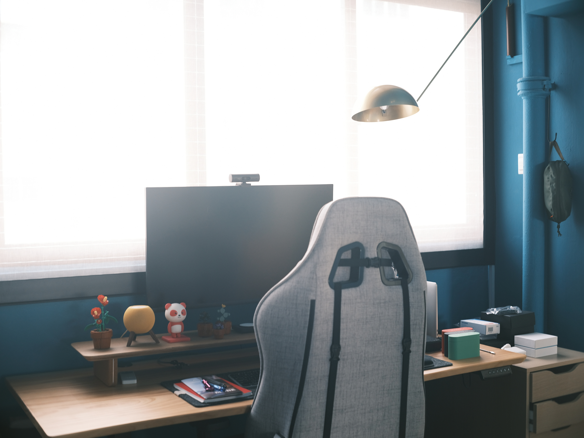 A chic turquoise study with dramatic double-volume windows - Modern workspace, ergonomic chair, blue wall, desk setup