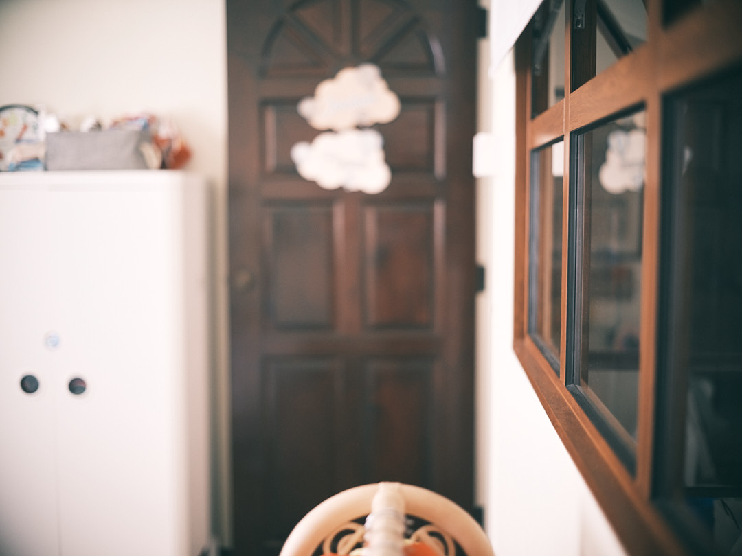 A charming bedroom for a golden childhood - Wooden door with decorative cloud motifs, white refrigerator with colorful