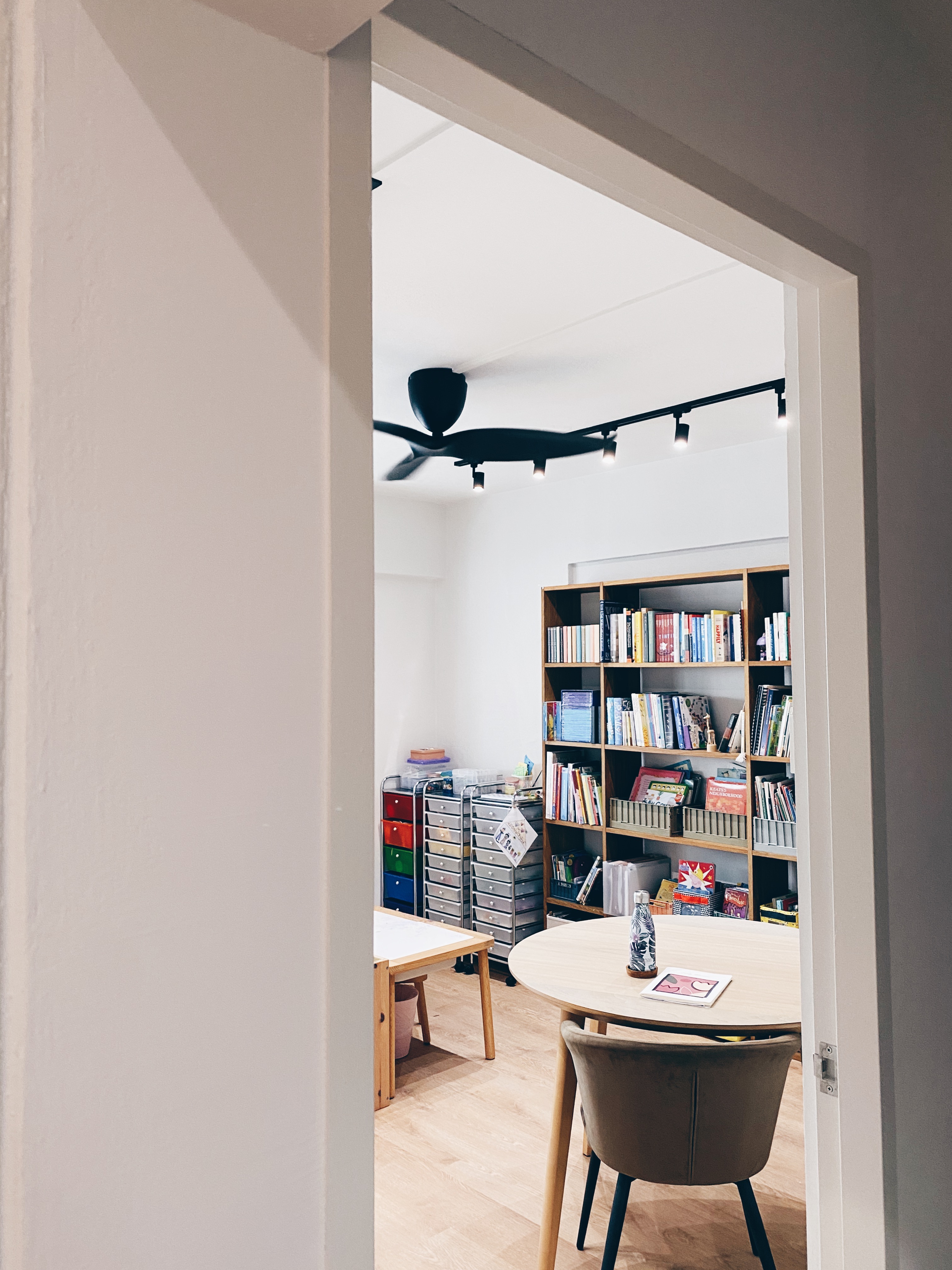 Cohabiting: working and playing together - Modern minimalist home office, cozy reading nook, open book, colorful bins