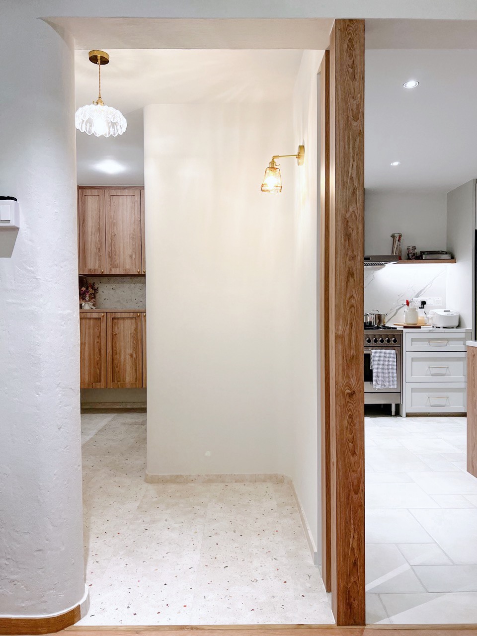 (work in place) doorways and corridors  - White kitchen with wooden cabinets, modern pendant lights, speckled white tile