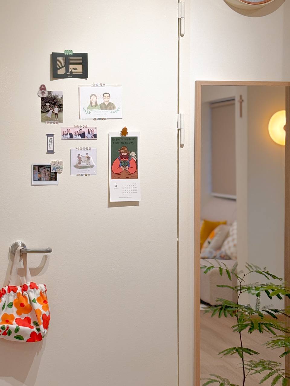 Top 3 Things for an Entryway - Wall with various photos, calendar, and decorative items, beige wall, small plant, colorful