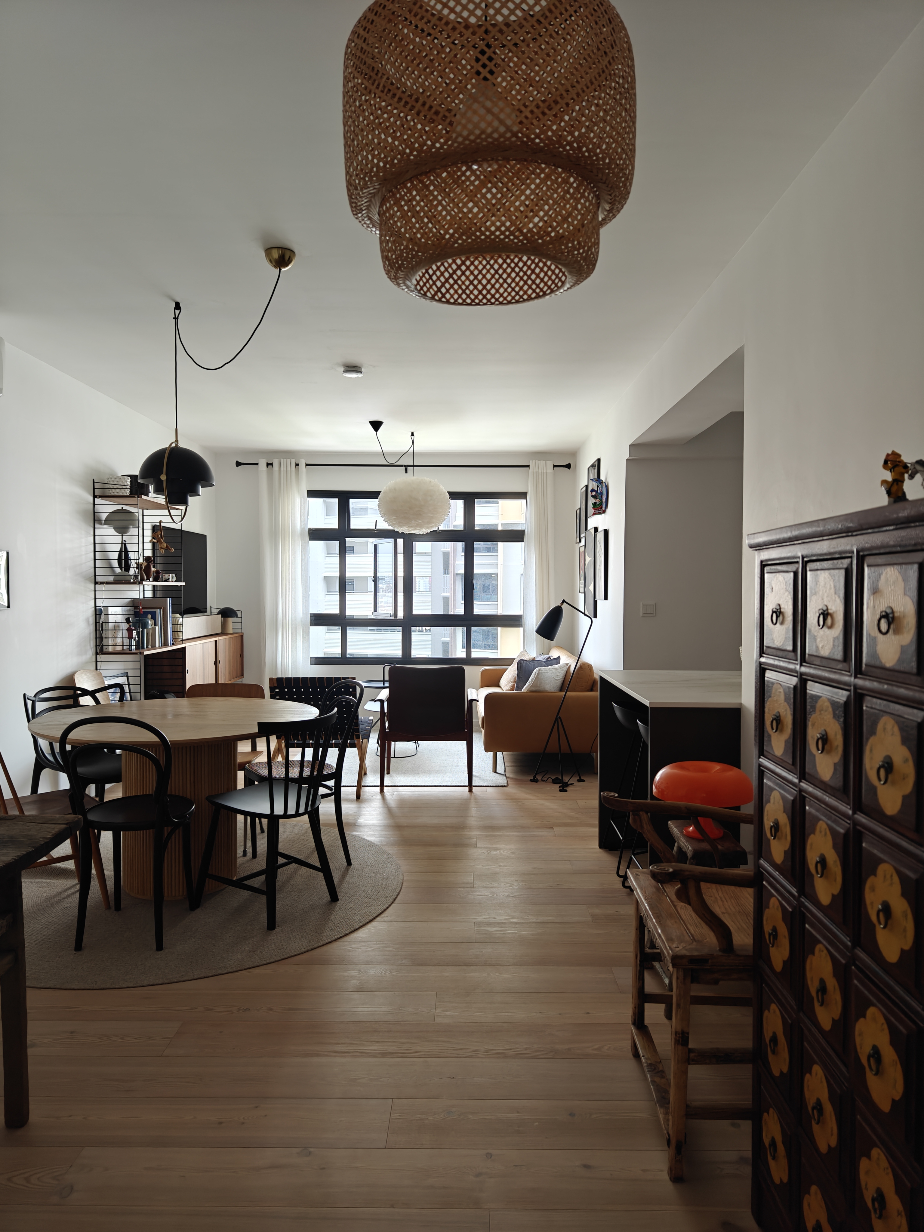 The Entry To Our World - Modern living room, minimalist design, large windows, natural light, wooden floor, round dining