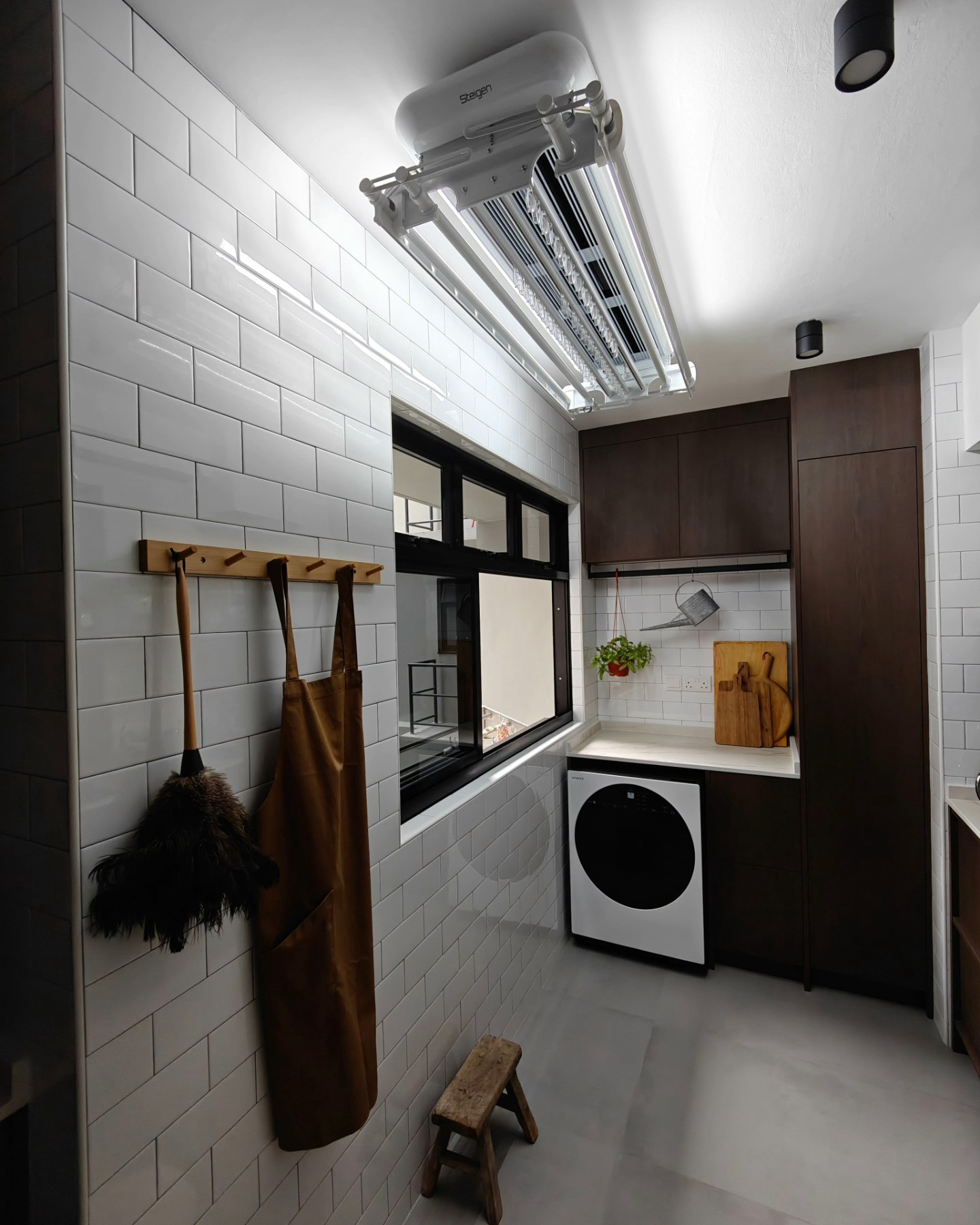 A Laundry Area Within A Kitchen - White tiled walls, modern kitchen, wooden cabinets, black and white tiled floor, built-in