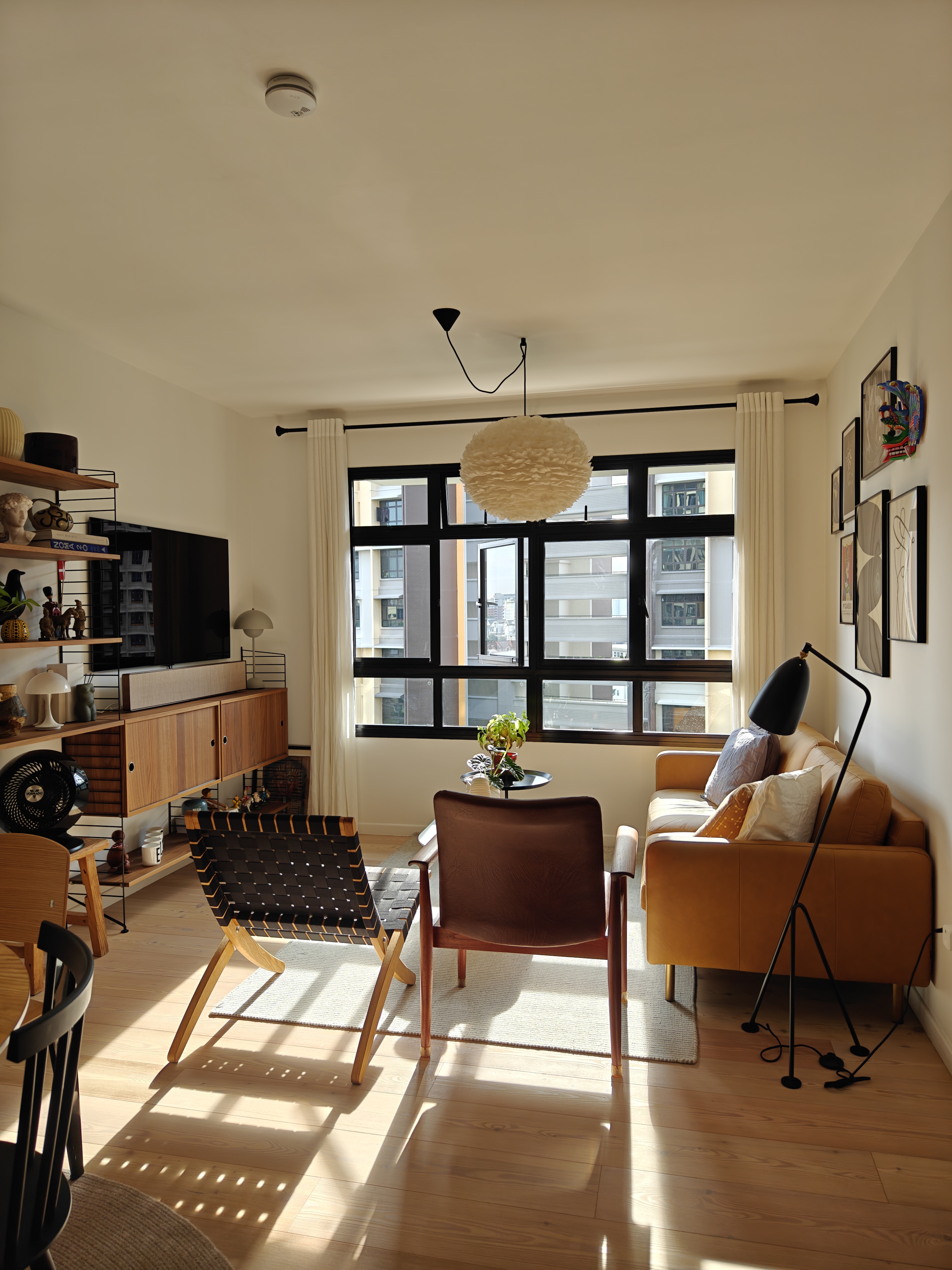 The Pride Of the_may_hem - Modern living room with large windows, beige and brown furniture, black and white decor, wooden