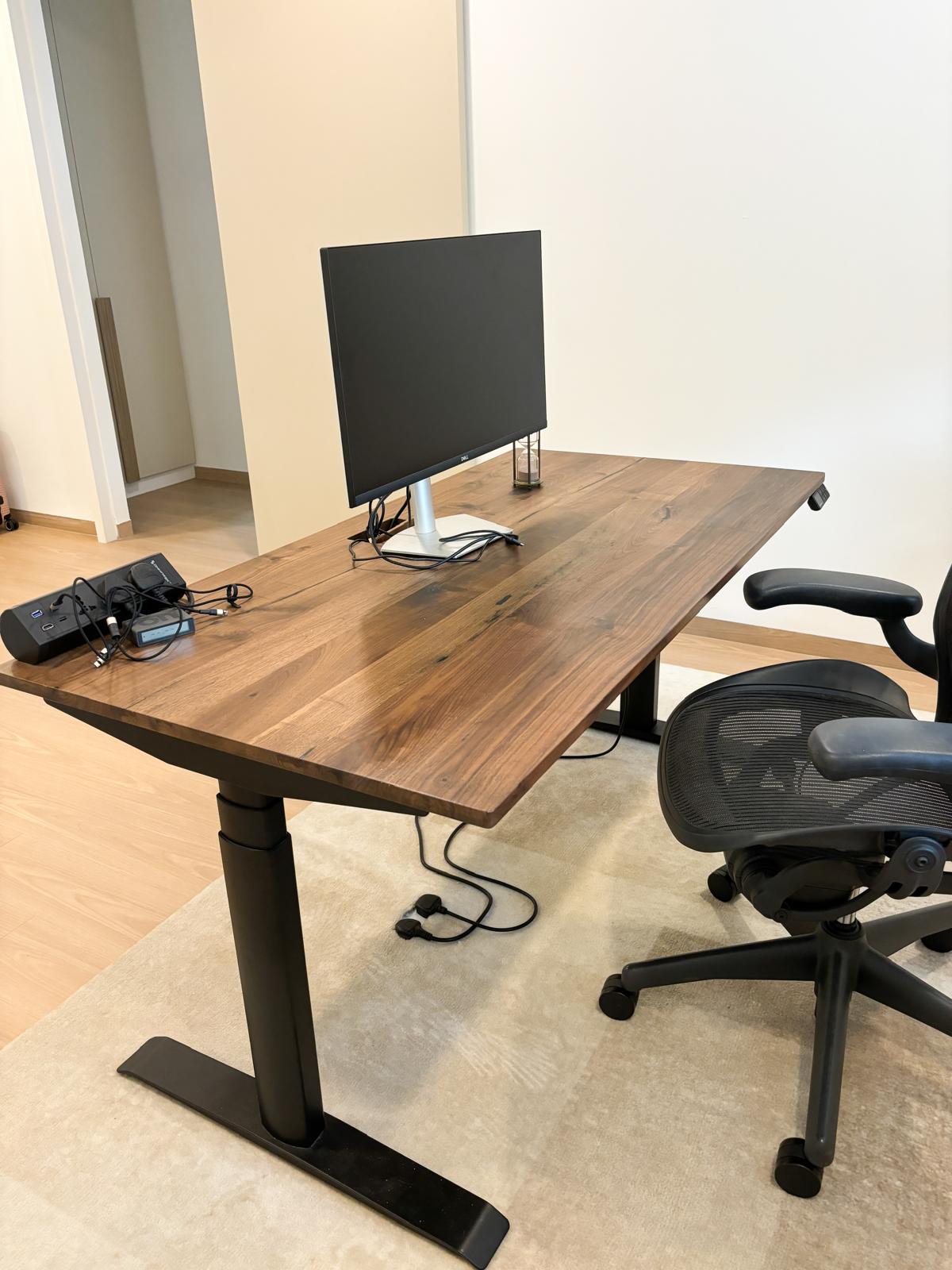 A comfortable and clutter-free WFH workspace to inspire productivity  - Wooden desk, black monitor, ergonomic chair, modern