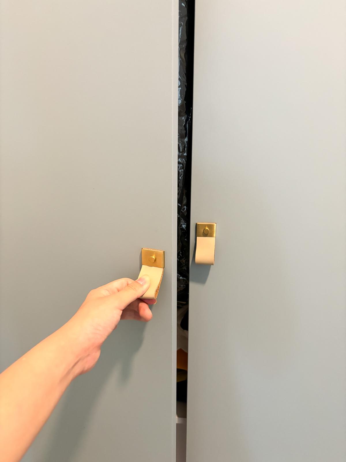 A safari themed kid's room  - Gold handle, silver lock, person's hand, silver handle, beige lock, gray cabinet, door opening