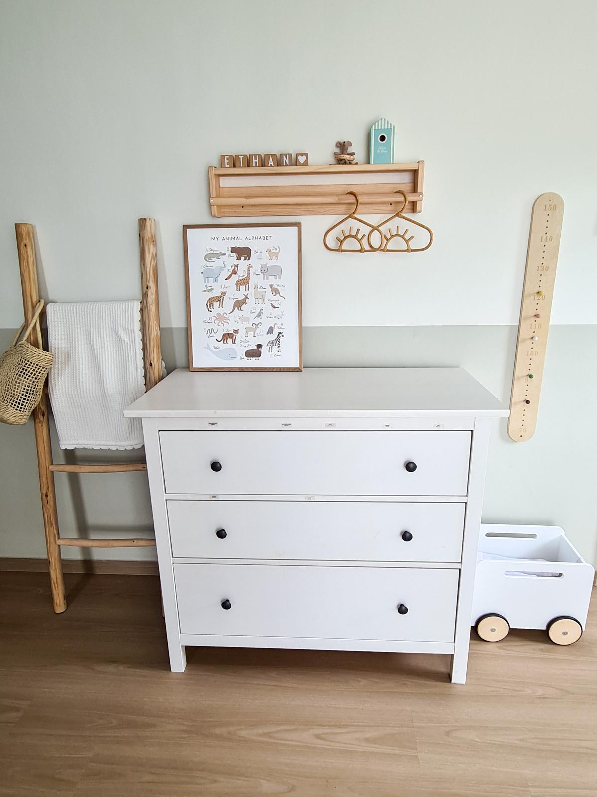 A safari themed kid's room  - Wooden crib, white dresser, wooden hanger, wooden shelf, wooden birdhouse, wooden basket