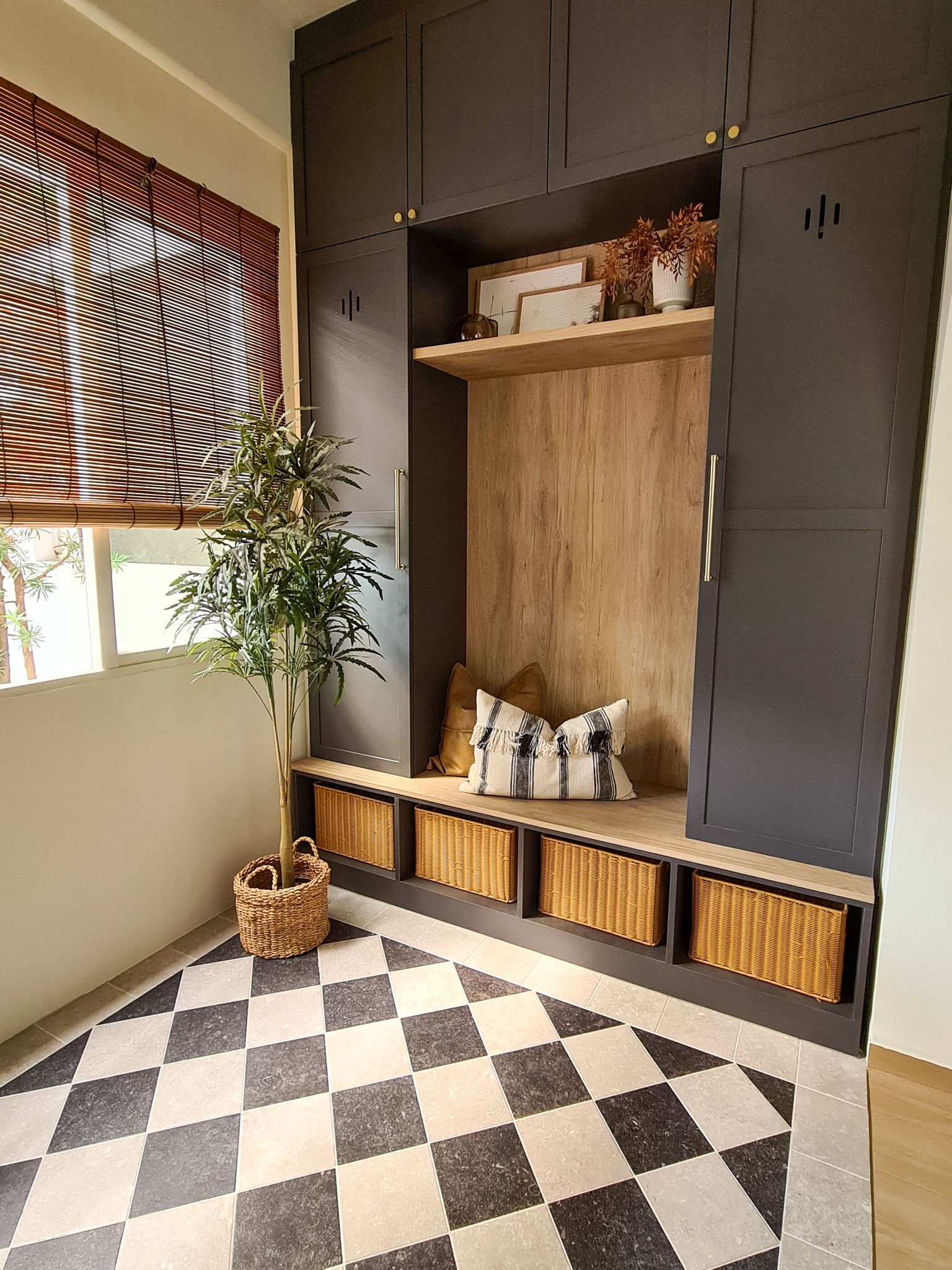 Creating a functional and cosy entryway  - Dark wooden cabinets, woven baskets, black and white checkered floor, tall potted