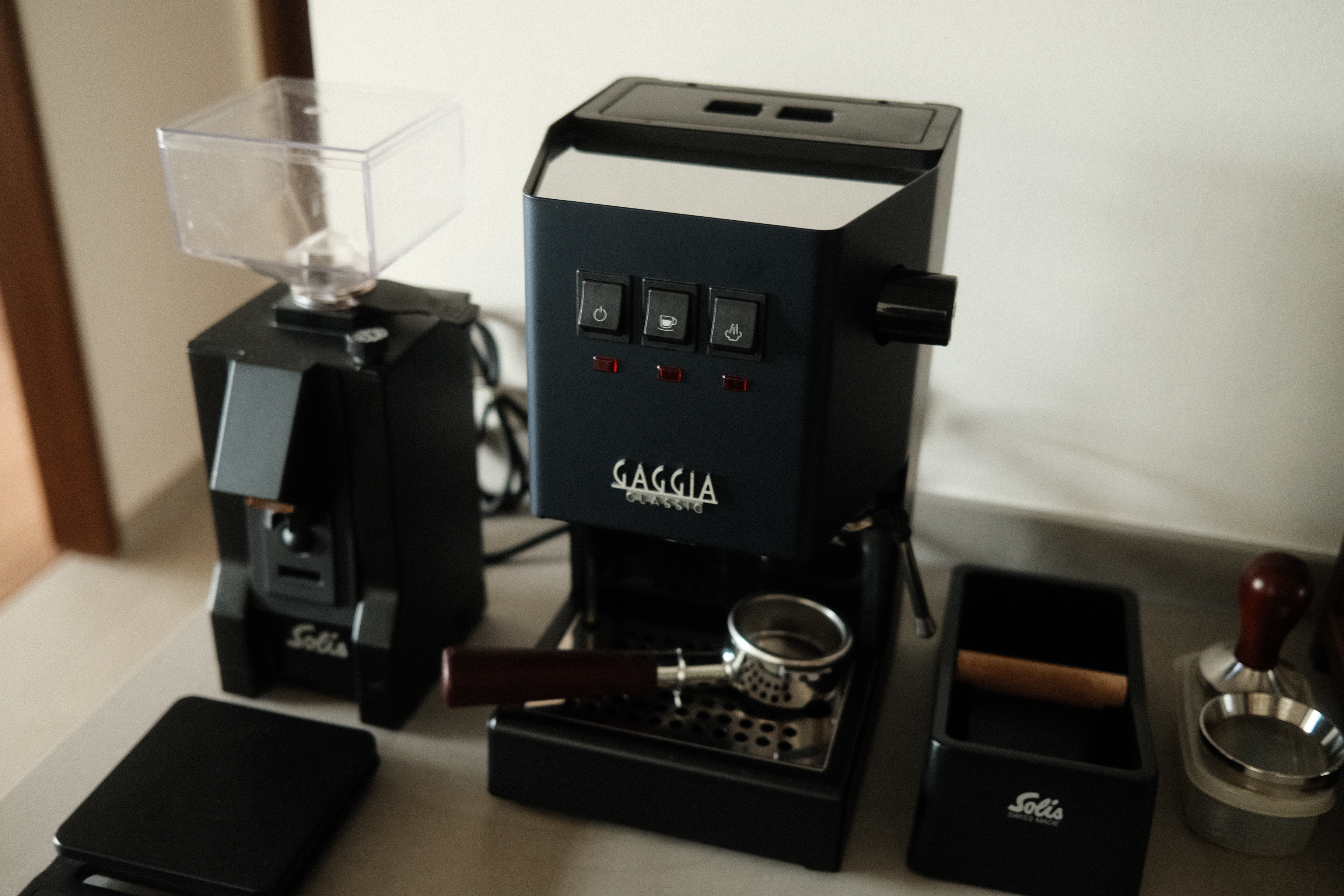 Setting up a coffee bar at home - Black coffee machine, Gaggia Classic, manual coffee brewing, clear grinder, wooden handle