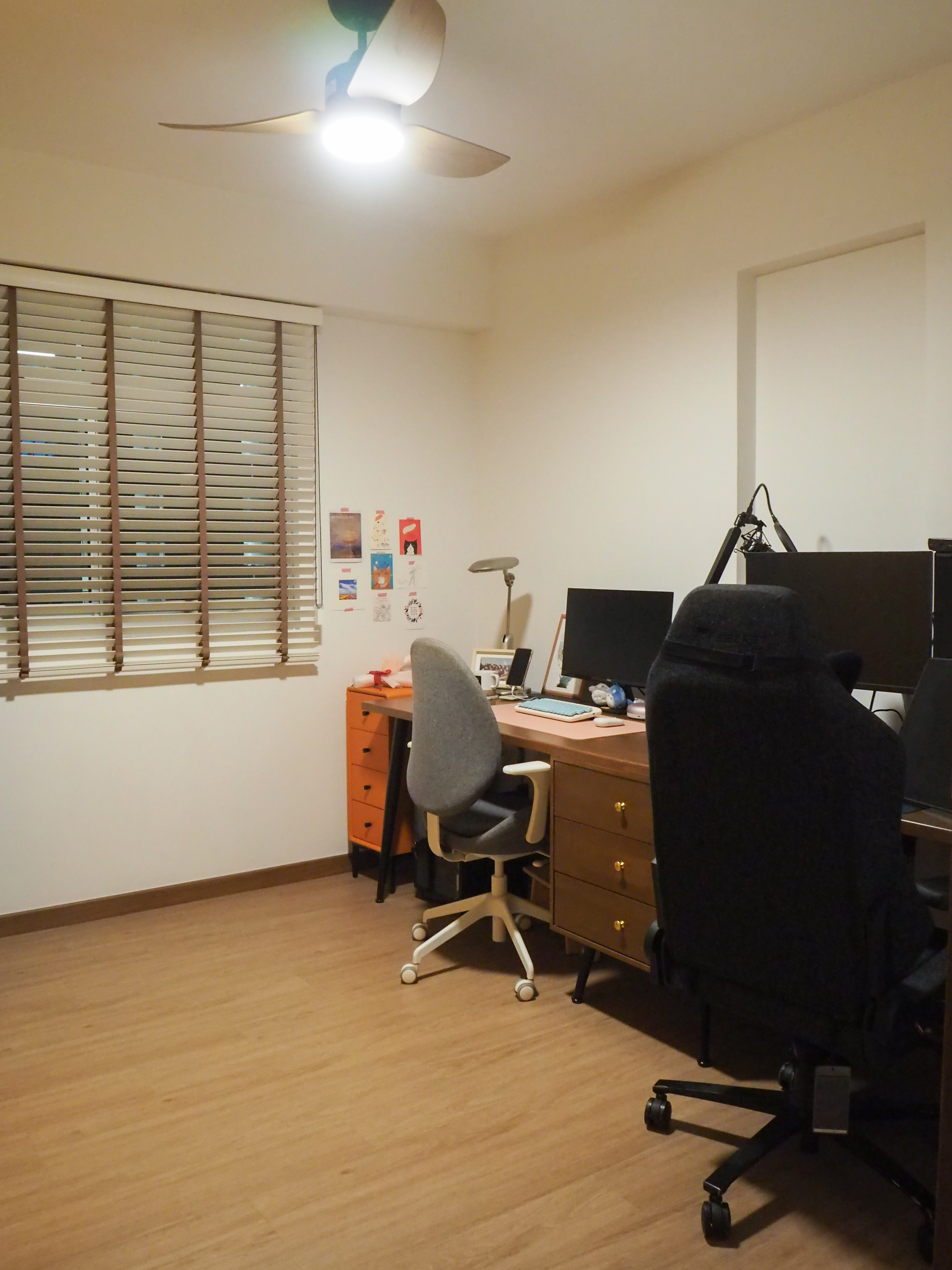 Our Workspace with zero built-in + pops of colours - Wooden desk, black office chair, ceiling fan, light fixture, beige