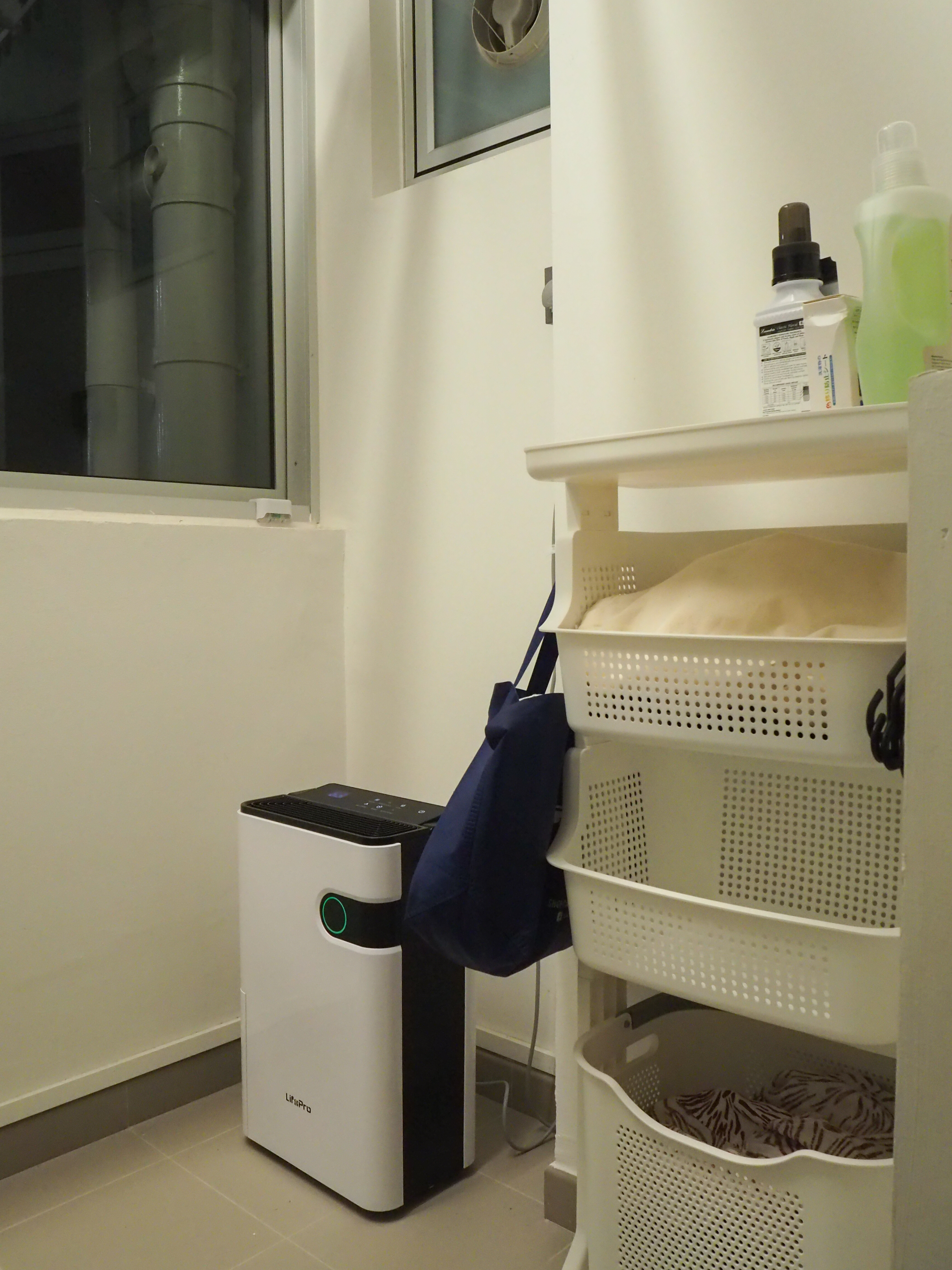 Our WIP simple service yard - White laundry dryer, beige laundry basket, blue tote bag, white shelf unit, perforated white