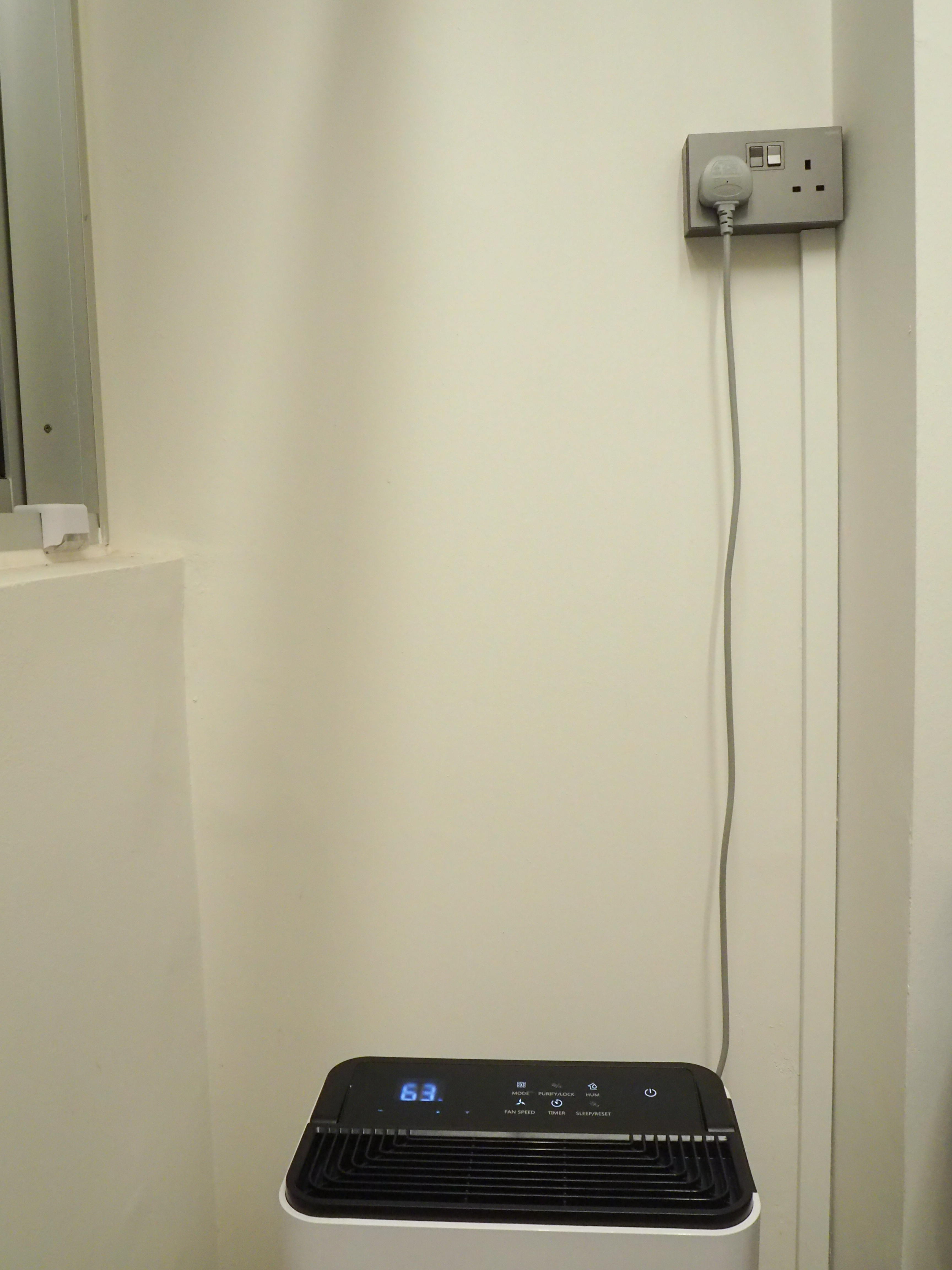 Our WIP simple service yard - Wall-mounted electrical outlet, gray plug, white paper towel holder, white wall, light beige