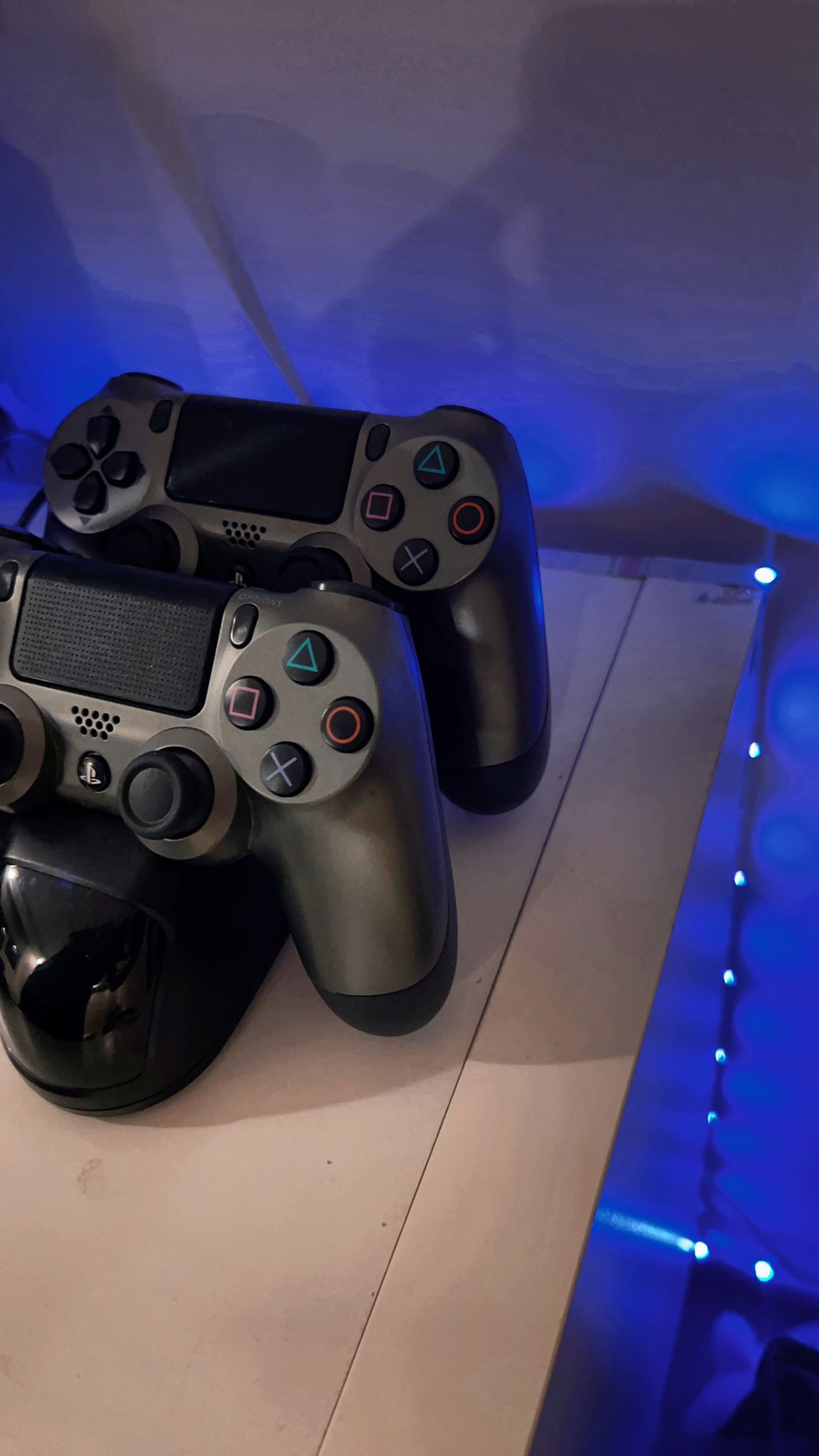 From Bedroom to Entertainment room - black PlayStation 4 controllers, blue ambient lighting, sleek design, glossy finish