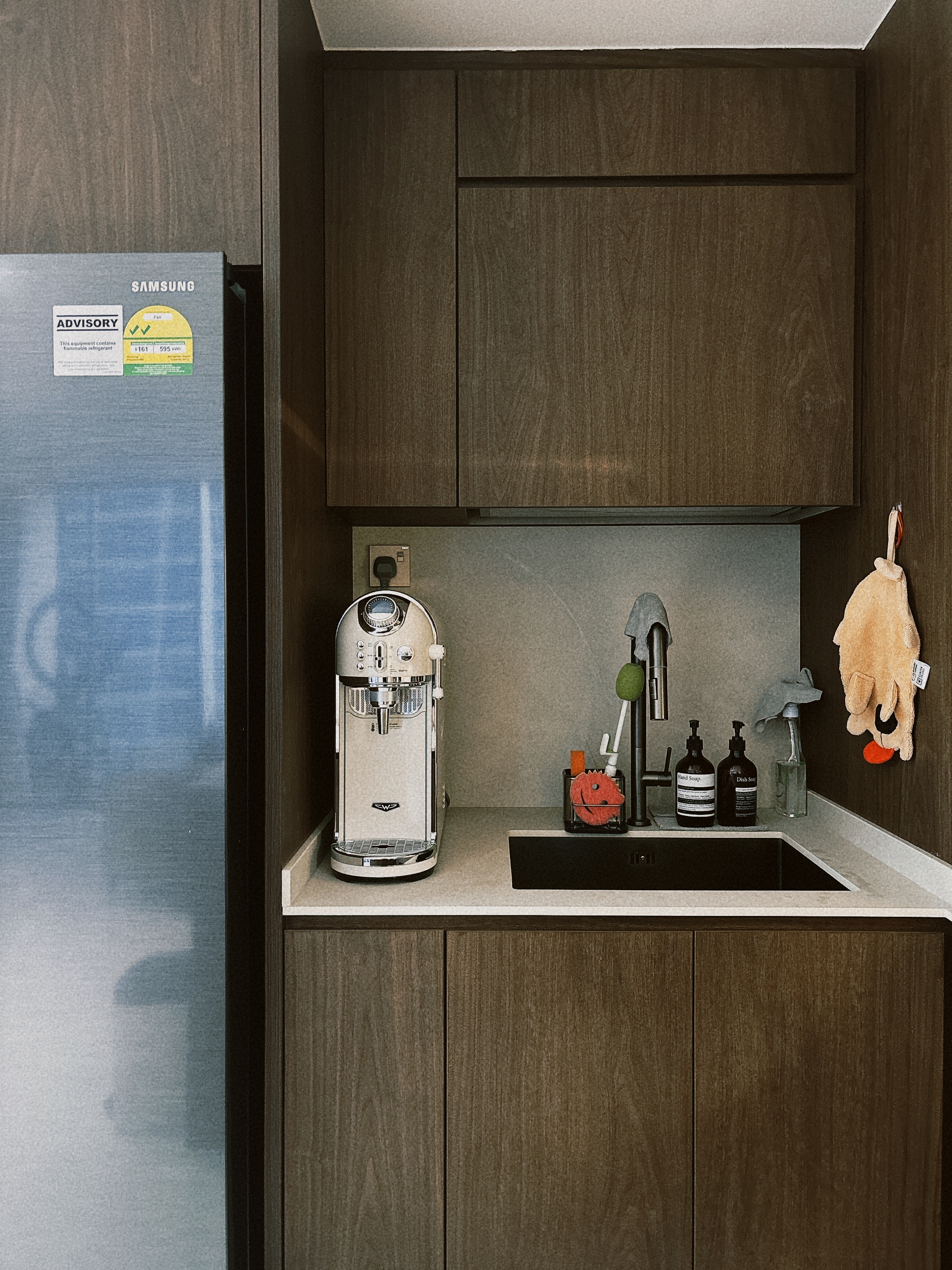 Our six-tile kitchen  - Modern kitchen with stainless steel refrigerator, wooden cabinets, sleek coffee machine, hanging