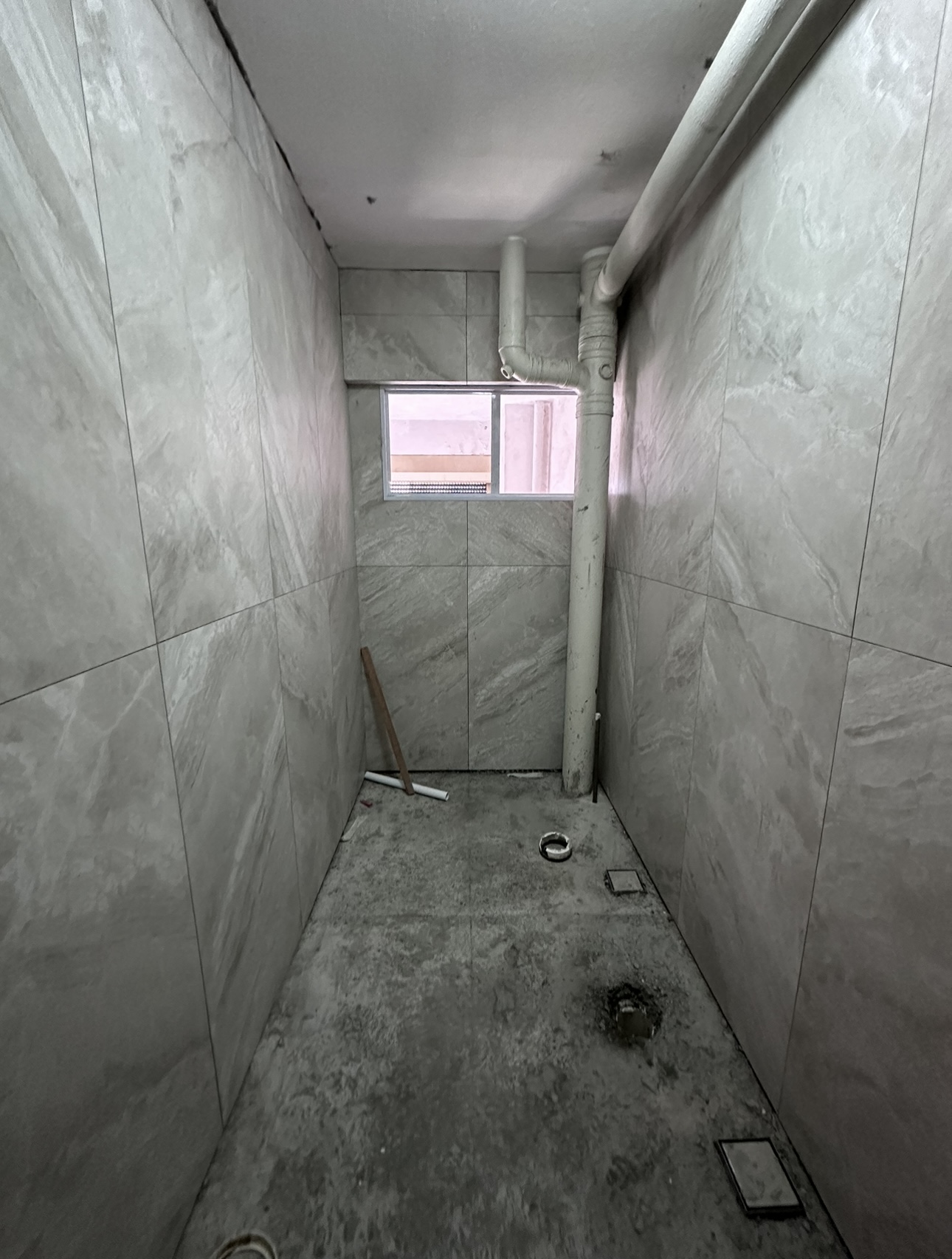 Join us in building our 3 bathrooms! - Gray marble tiles, unfinished walls, small window, exposed pipes, unfinished ceiling
