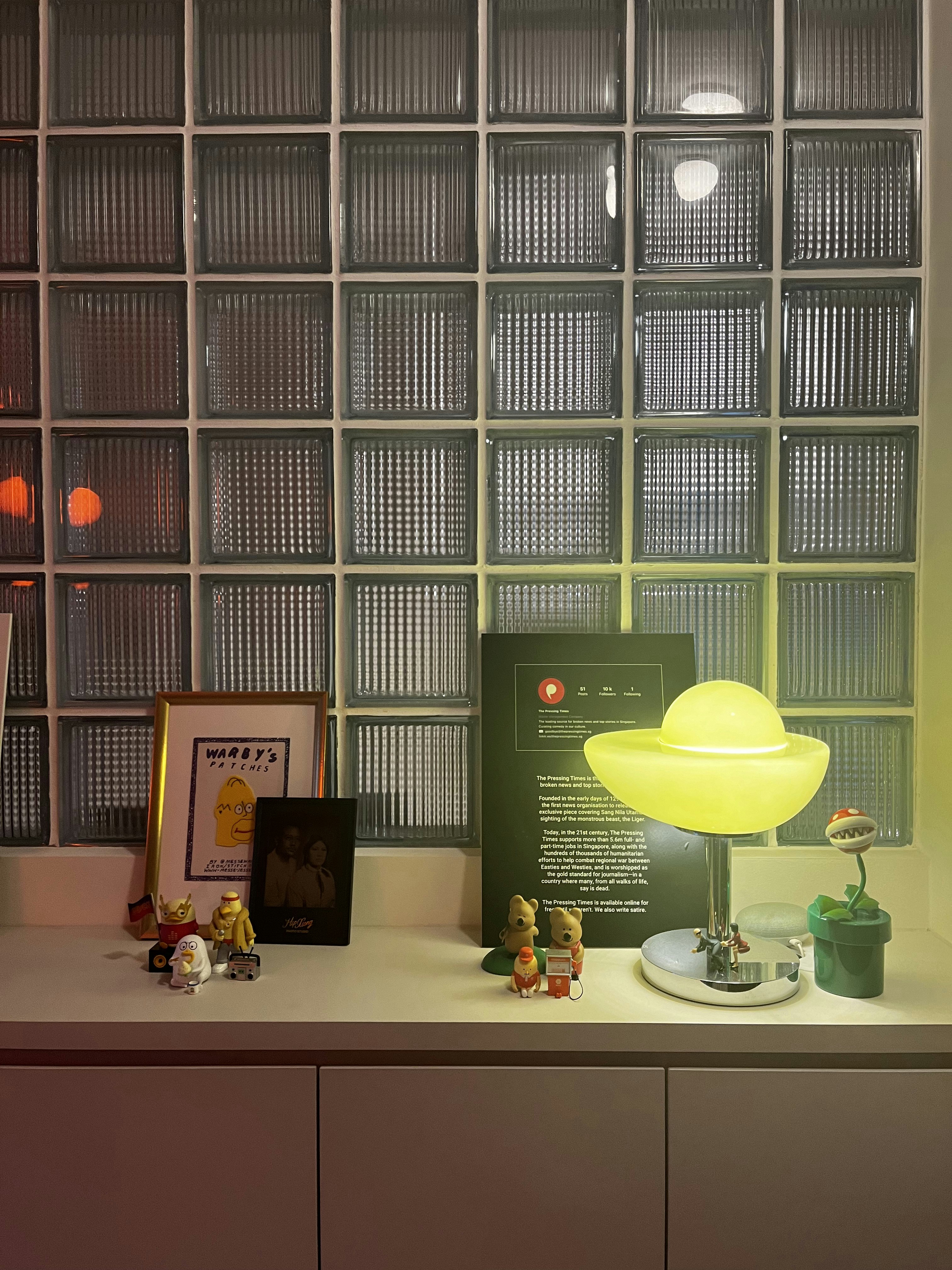 Feeling light-headed about lighting? Here’s some of our favourites. - Glass-paneled wall, framed poster, yellow lamp, small