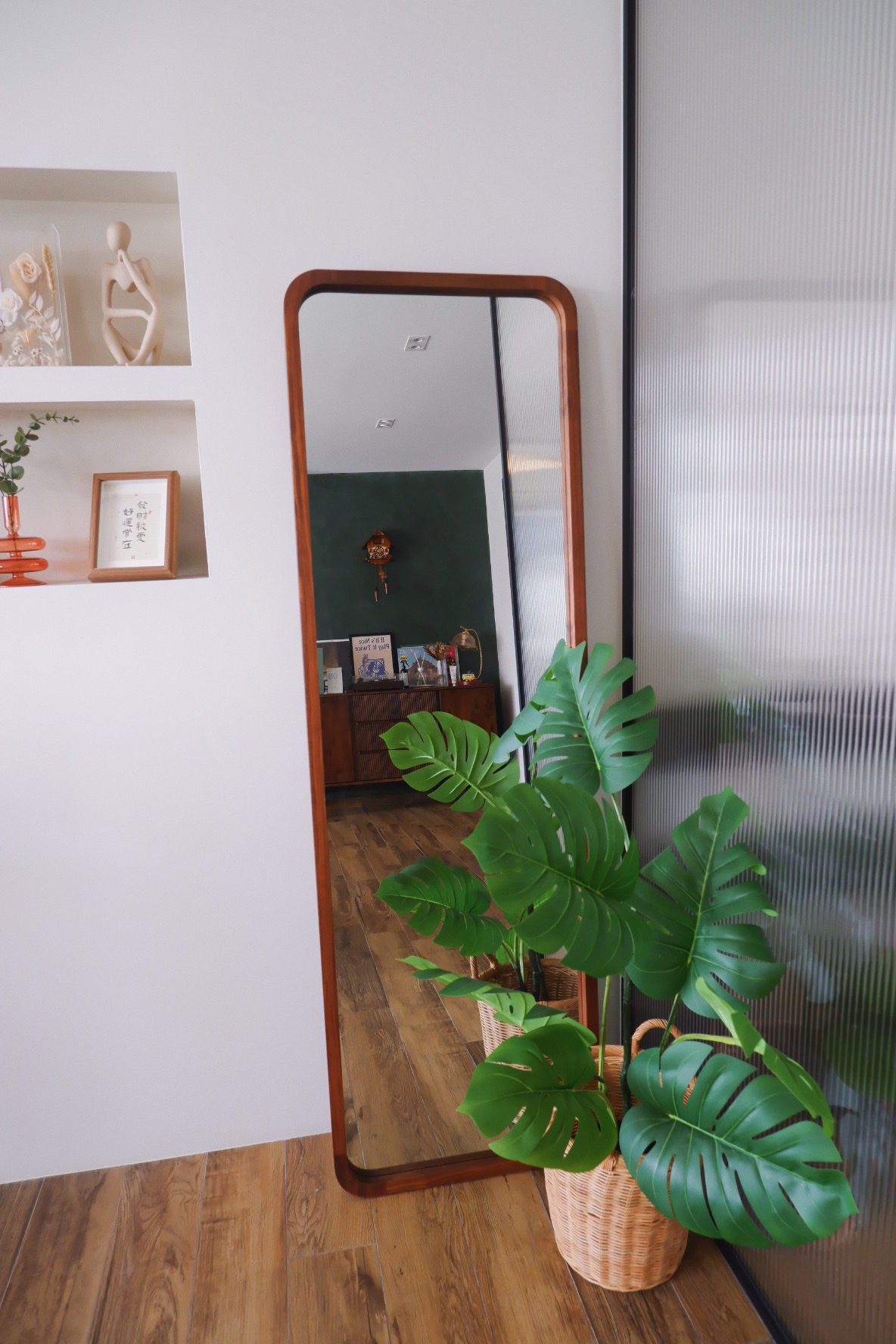 Our Entryway: "Hey Siri, I'm home"  - White wall with wooden shelf displaying various decorative items, including a sculpture