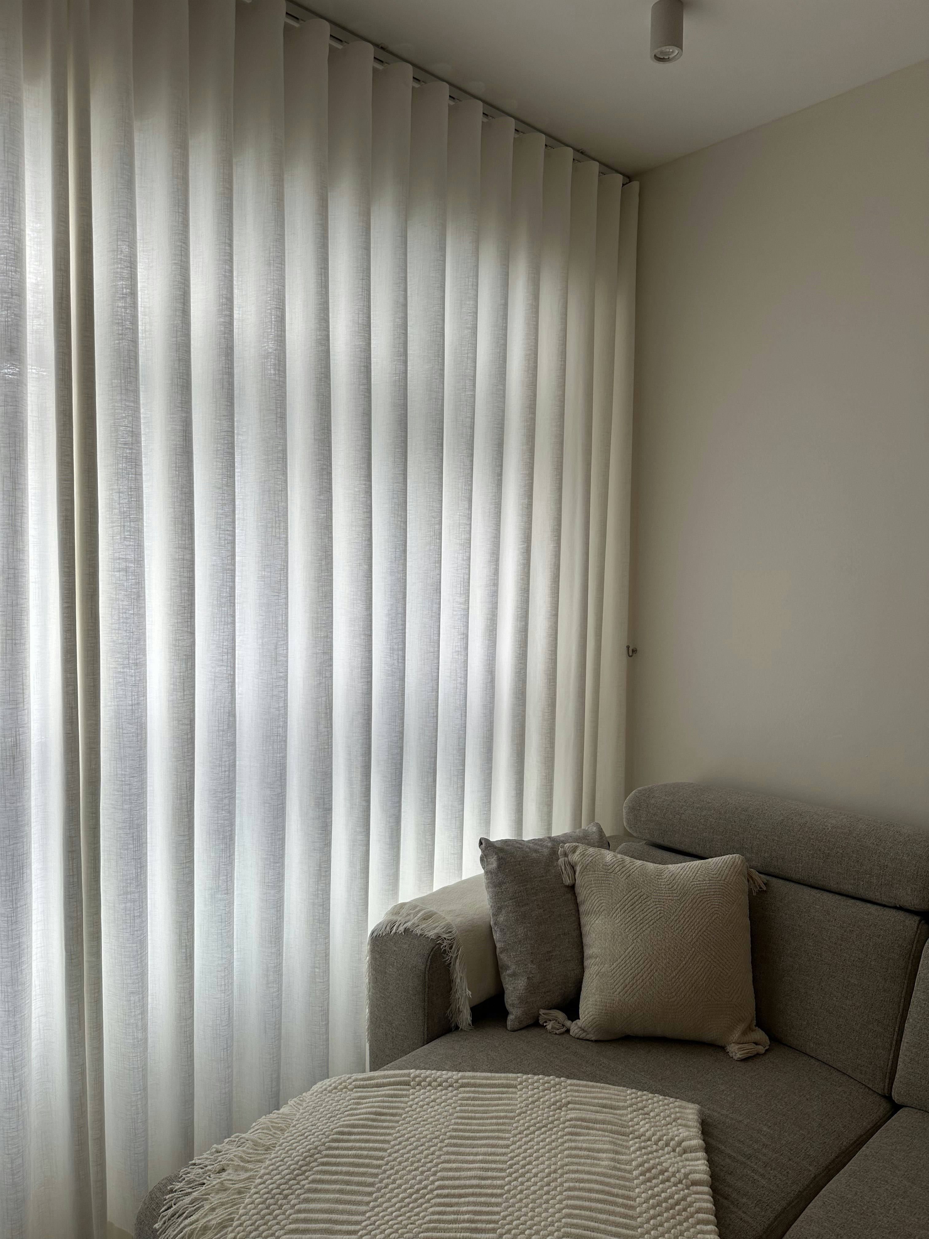Living room - our fave spot in the house! - Light-filtering curtains, soft natural light, neutral color palette, cozy sofa