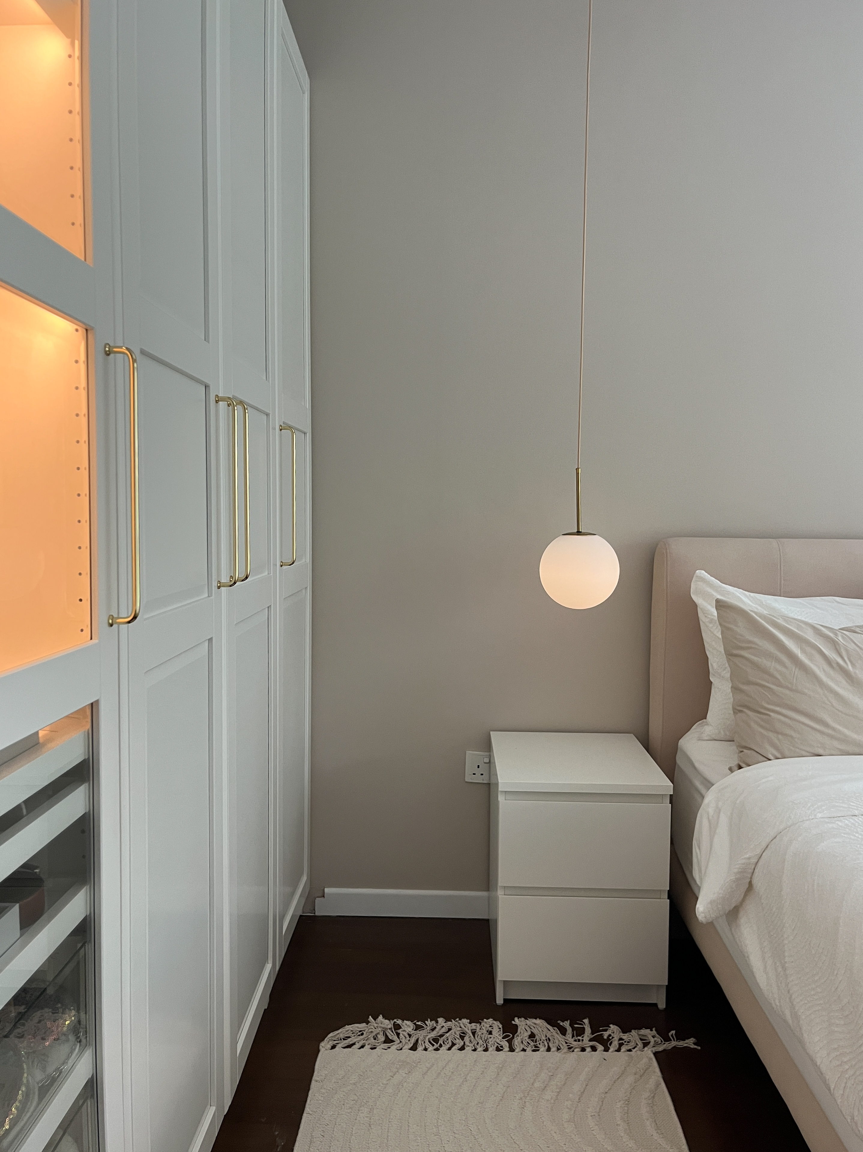 Our Cosy Bedroom to Wind Down & Relax - White modern wardrobe with gold handles, minimalist bedside table with round pendant