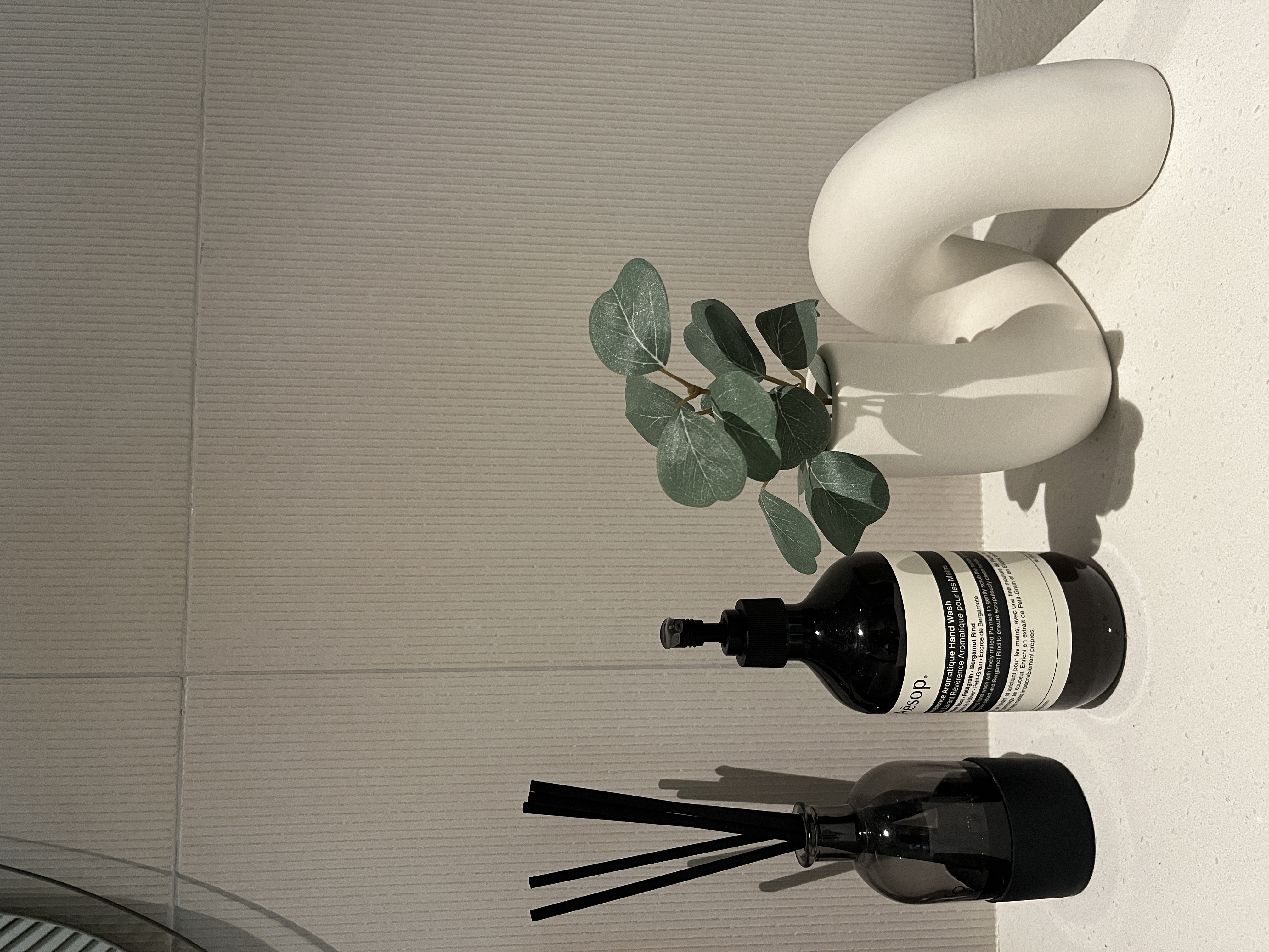 Our Bathroom Space - vibrant green plant, sleek white wall art, minimalist decor, modern bathroom, natural light, abstract