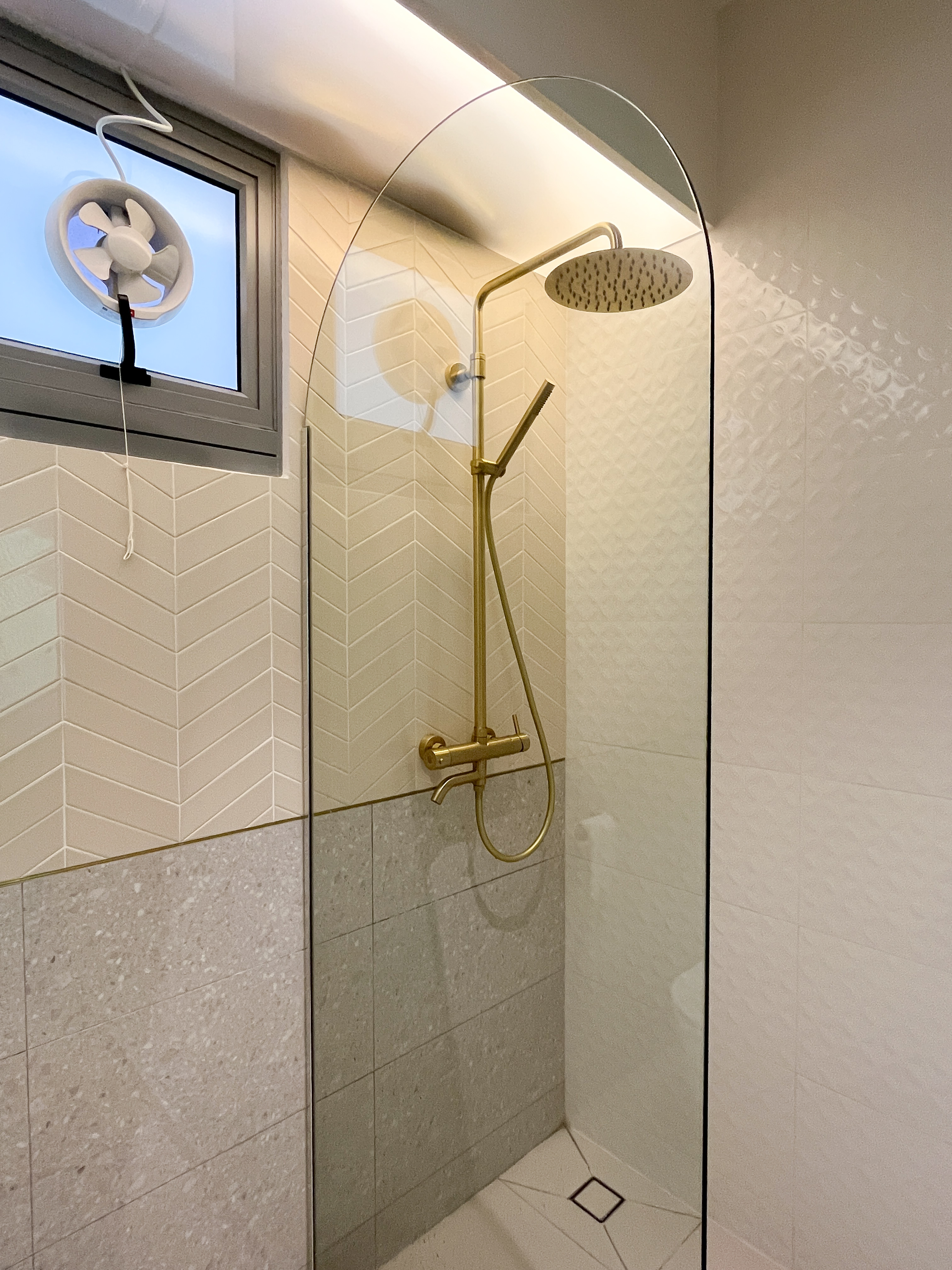 Our Bathroom Space - Glass-enclosed shower with gold fixtures, beige and gray tiled walls, modern design, stylish fixtures