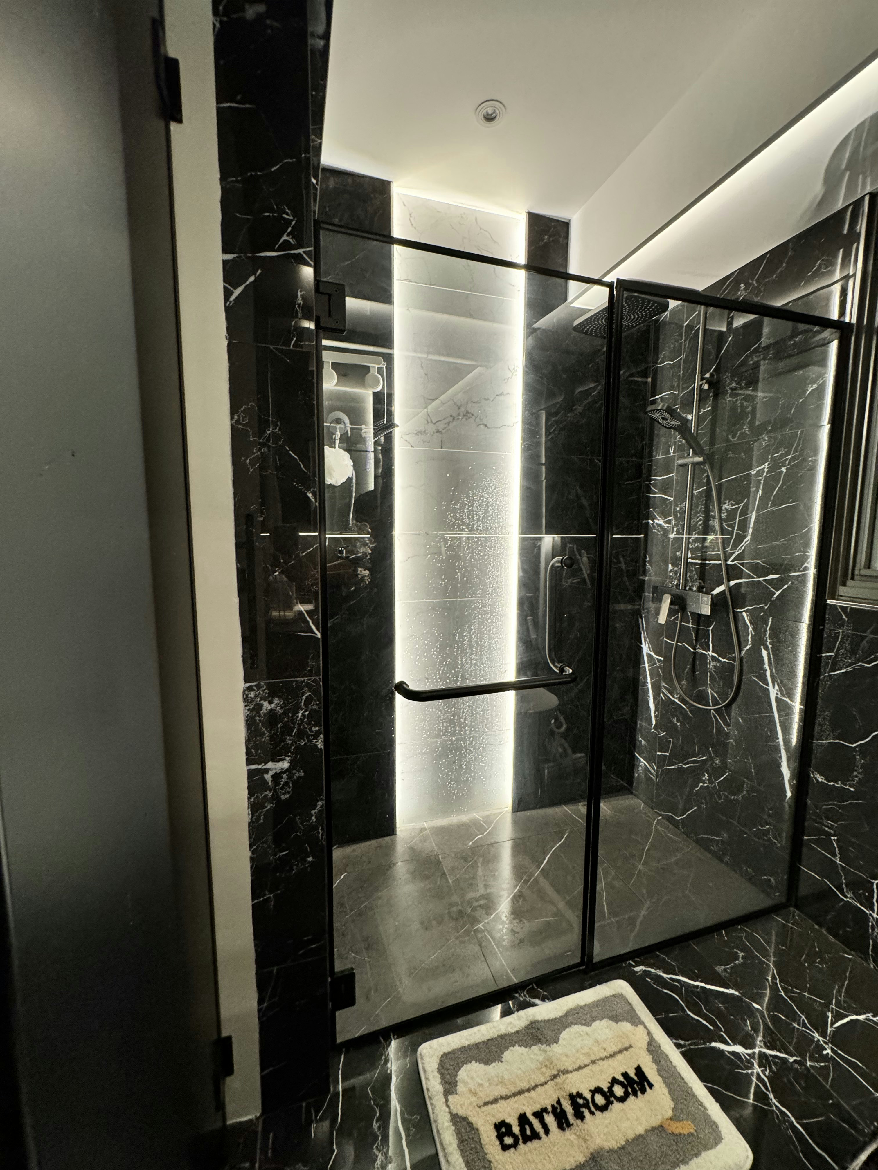 Cozy vibe with modern victorian style - Modern bathroom with sleek black marble walls and floor, featuring a glass-enclosed
