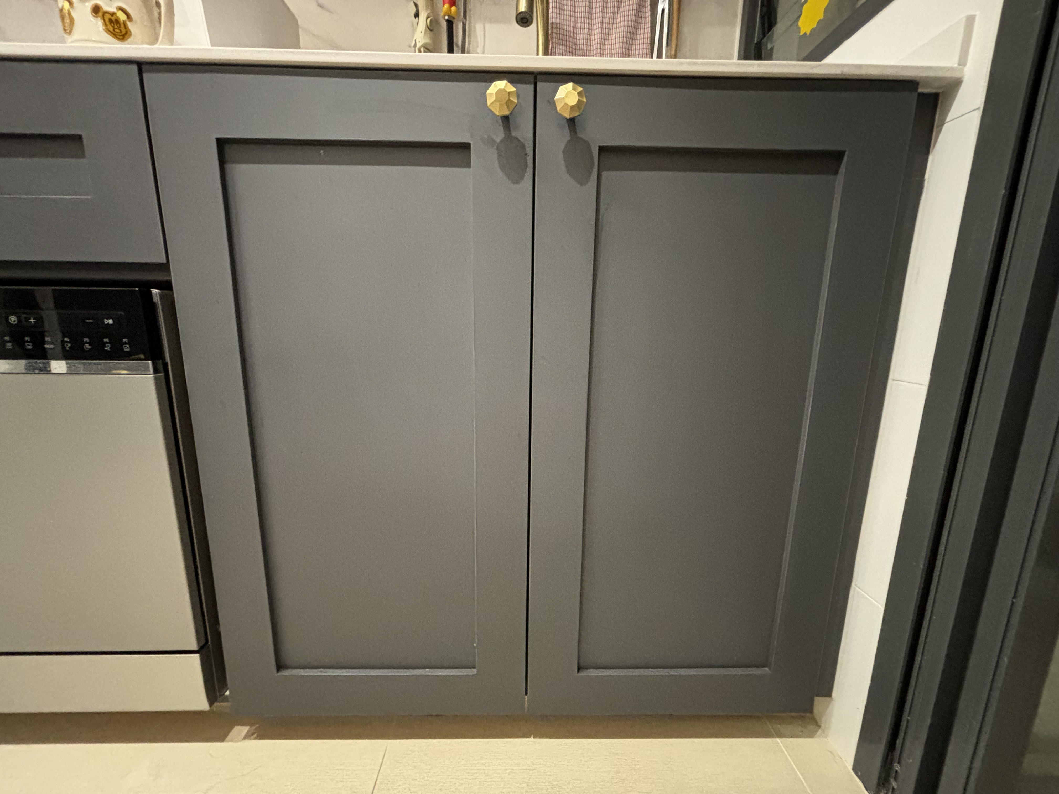 Home organization hacks for a more efficient home! - Gray kitchen cabinets with gold handles, stainless steel dishwasher