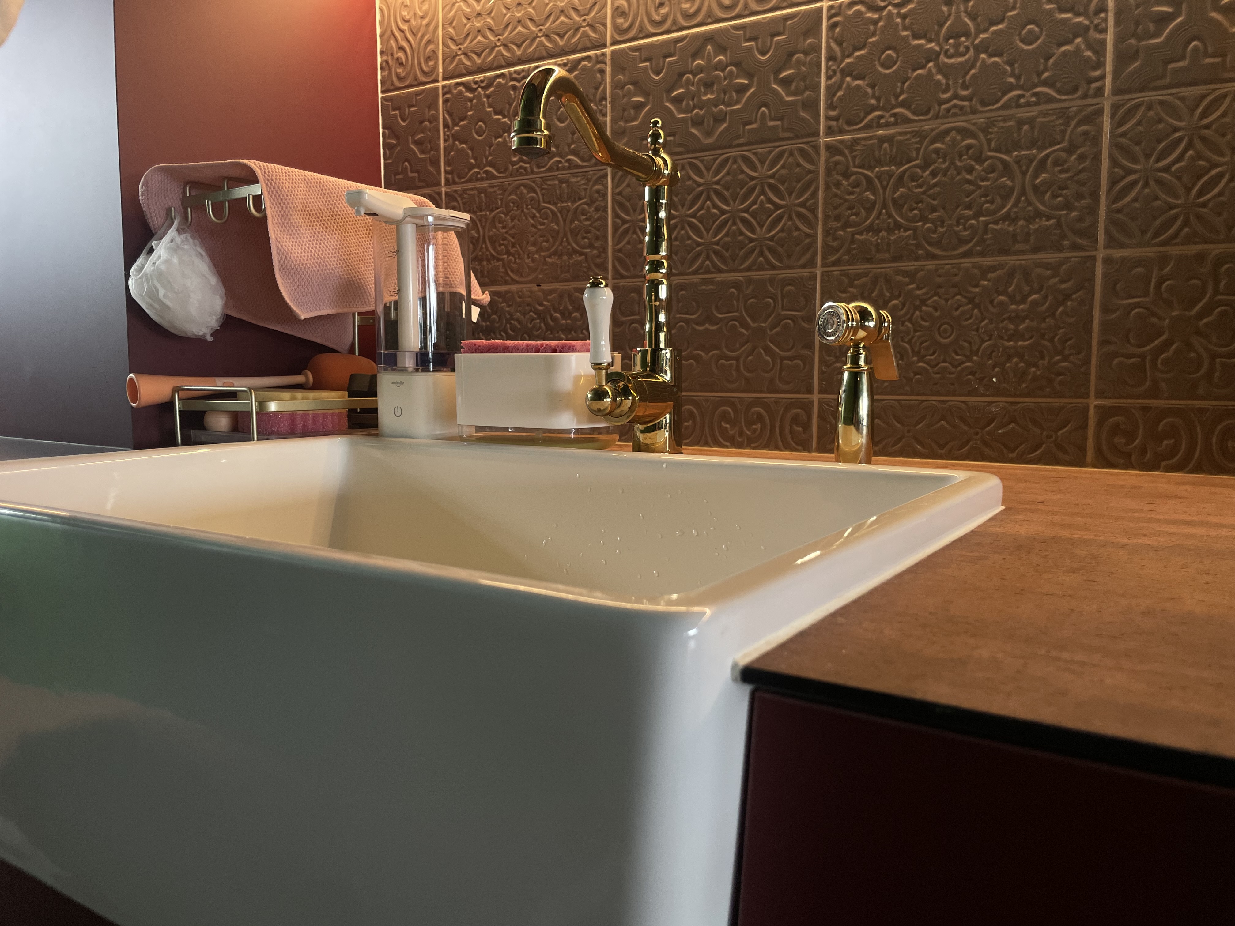 A unique blend of mid-century charm & cottage coziness - White rectangular sink, gold faucet, ornate brown wall tiles, modern