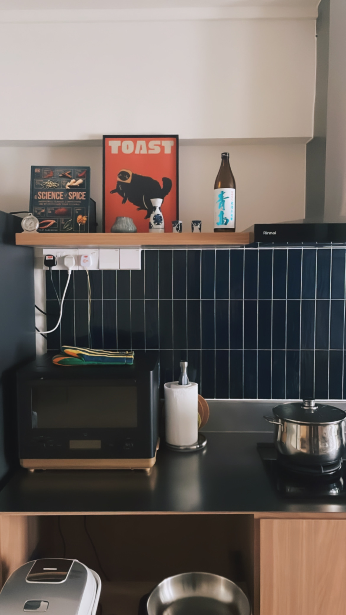 reviving resale HDB corridor unit with mid-mod twist! - Toaster, microwave, black countertop, dark blue tiled backsplash
