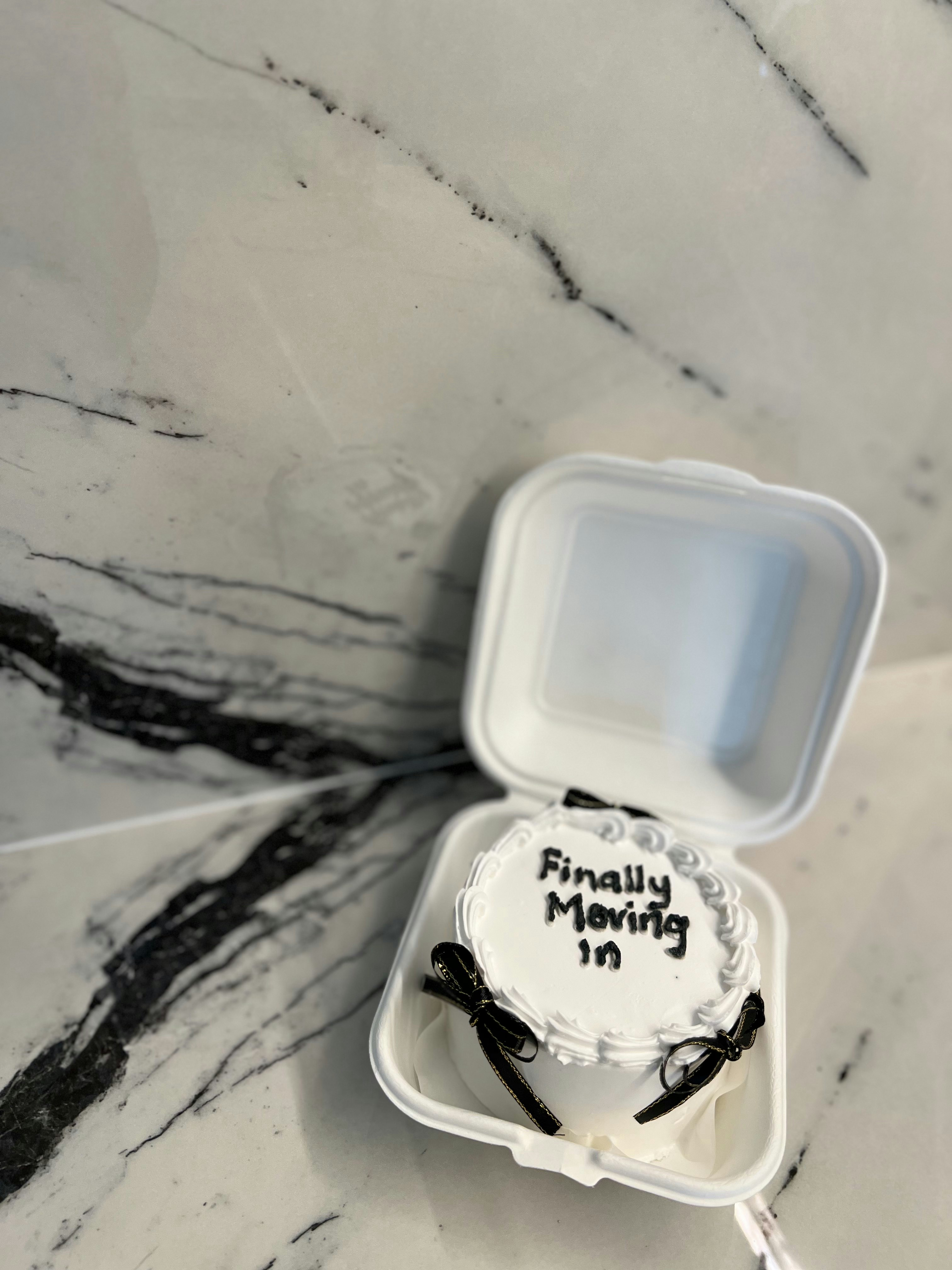 Welcome to our newly renovated 30 ish year old HDB jumbo! - White styrofoam container, marble countertop, black ribbon