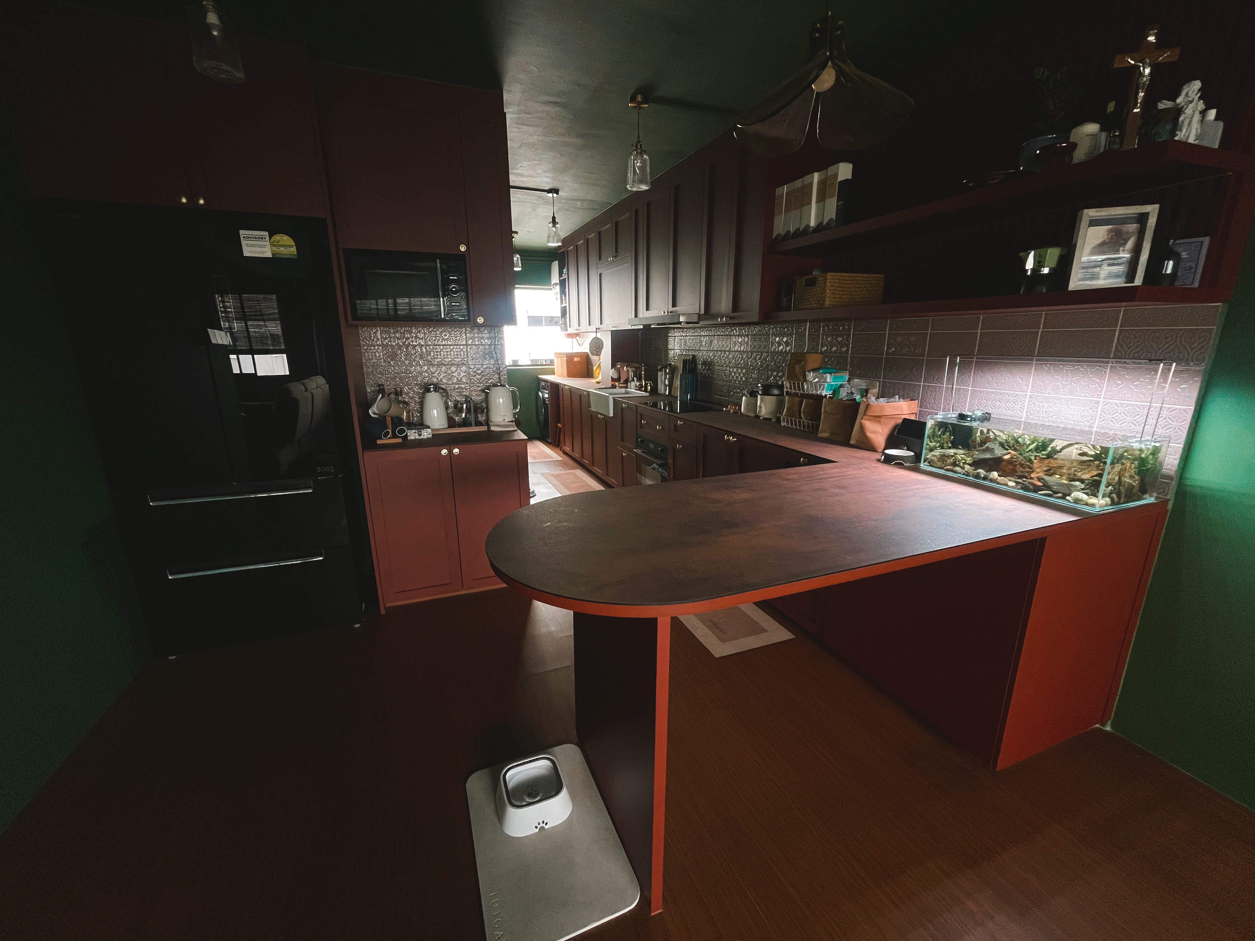 A unique blend of mid-century charm & cottage coziness - Dark kitchen with wooden cabinets, modern appliances, dark