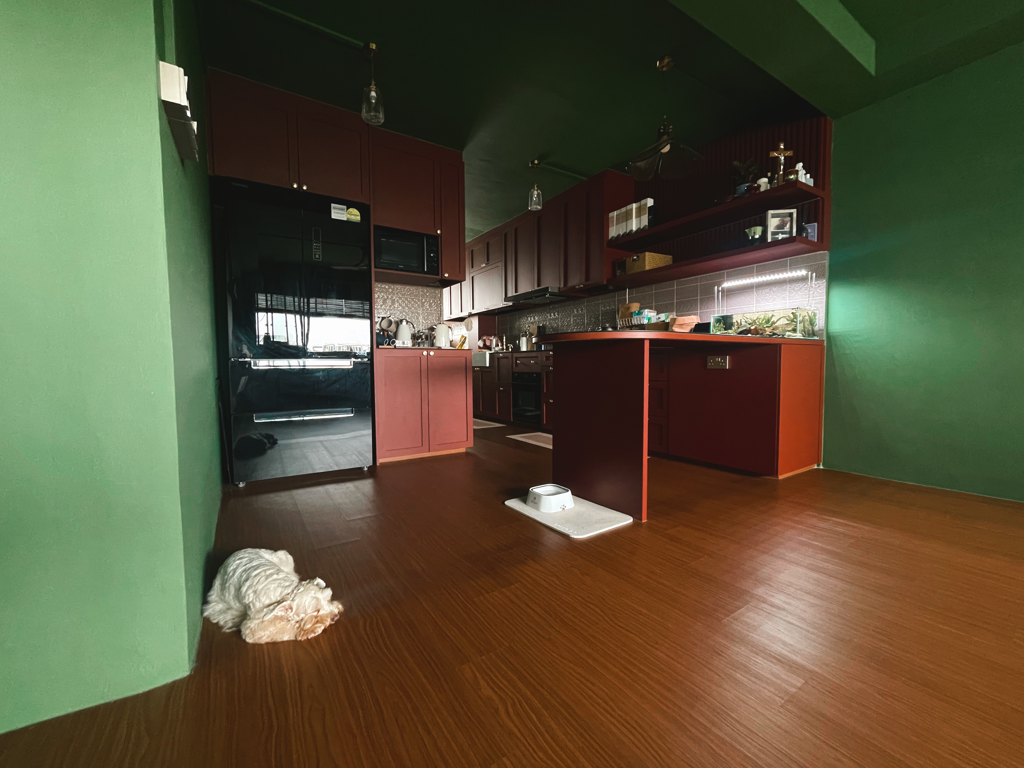 A unique blend of mid-century charm & cottage coziness - Kitchen cabinetry, green walls, red cabinets, black refrigerator