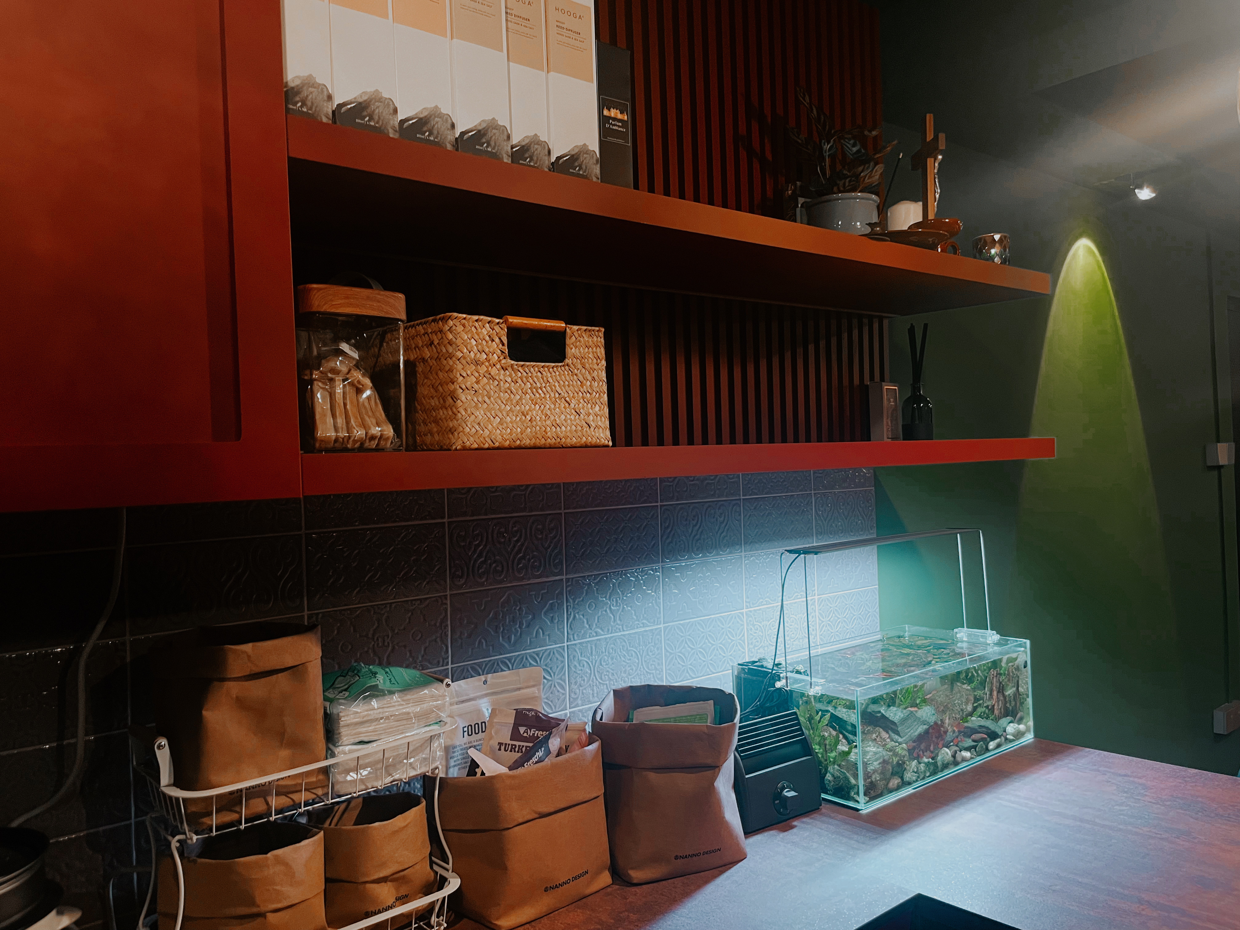 A unique blend of mid-century charm & cottage coziness - Shelf with various items, including boxes, baskets, and bags, on a