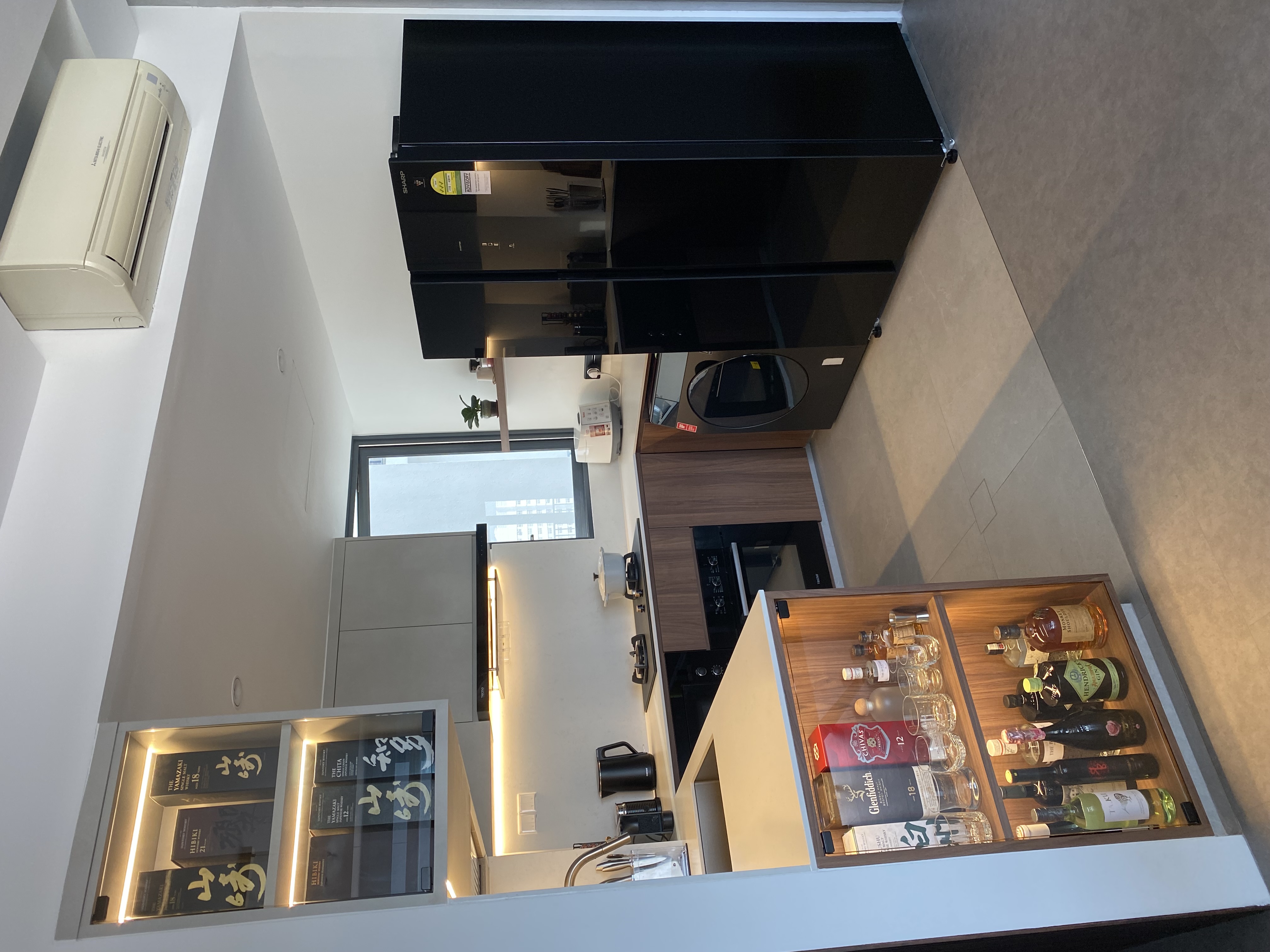 A home gallery and library in dark wood and grey tones - Modern kitchen with sleek appliances, minimalist design, integrated