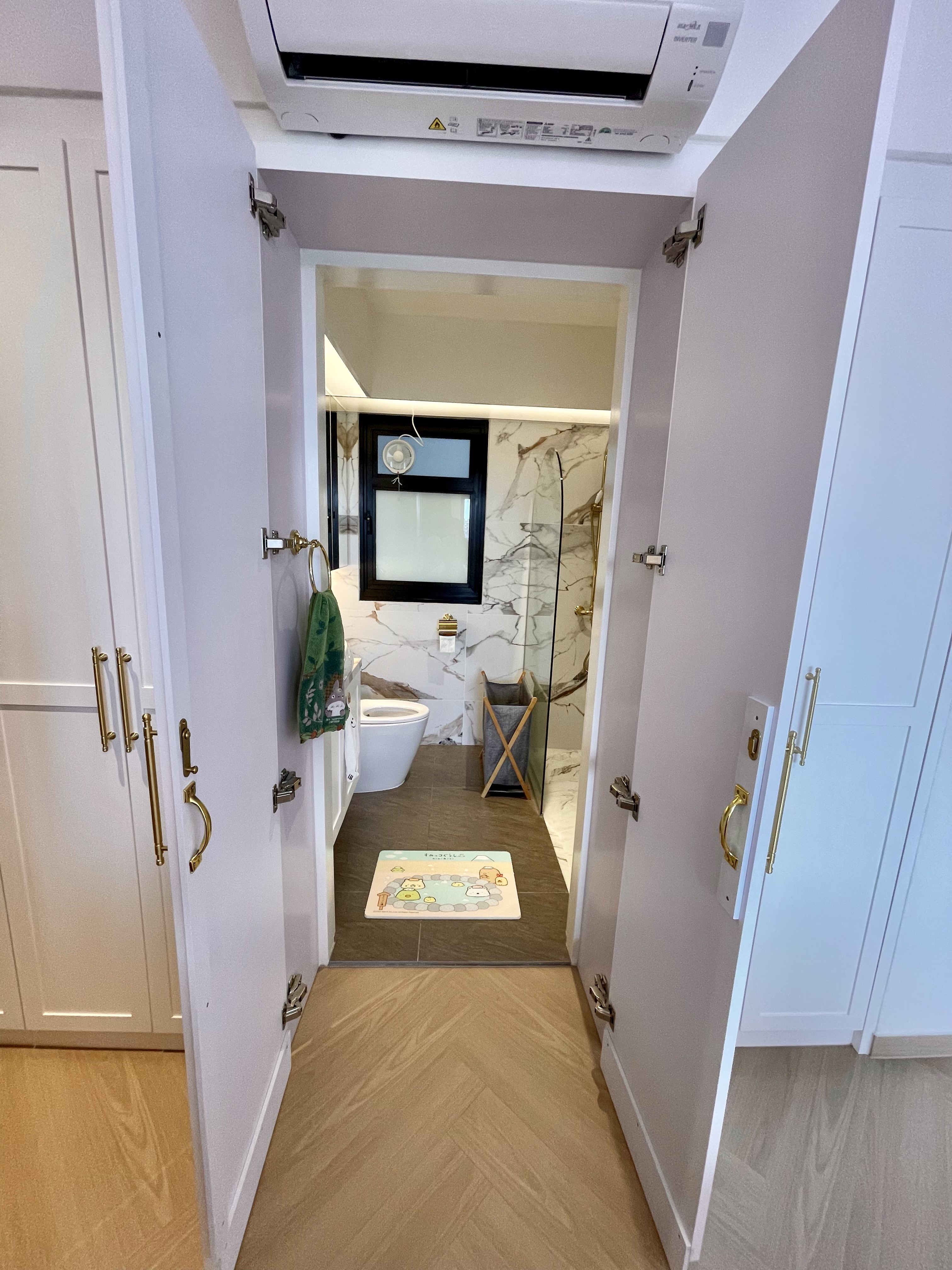 A Self-designed Cosy Abode at Woodleigh Hillside - White bathroom with gold handles, marble tiles, green towel, wooden floor