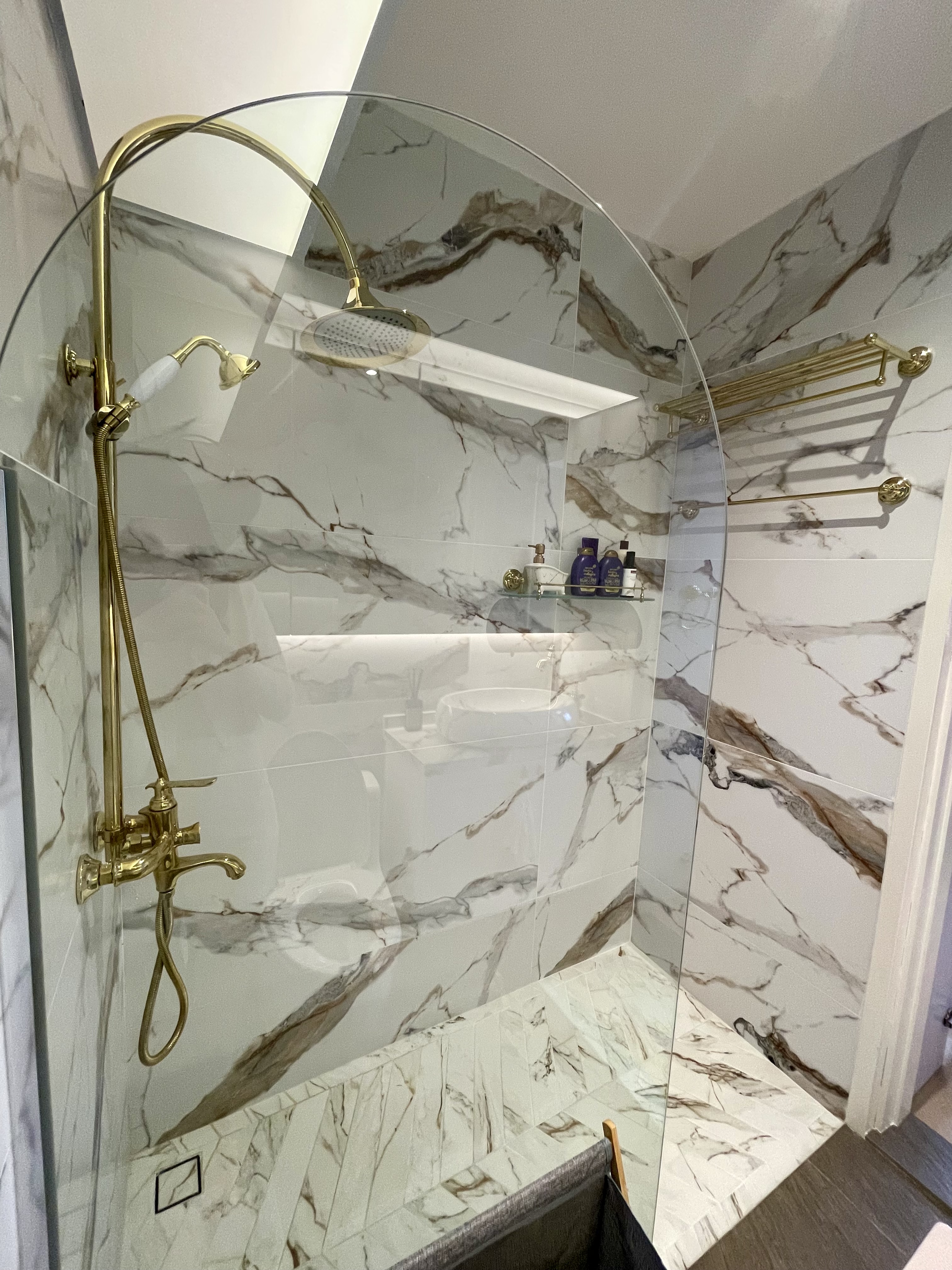 A Self-designed Cosy Abode at Woodleigh Hillside - Marble-patterned walls, gold fixtures, glass shower enclosure, modern