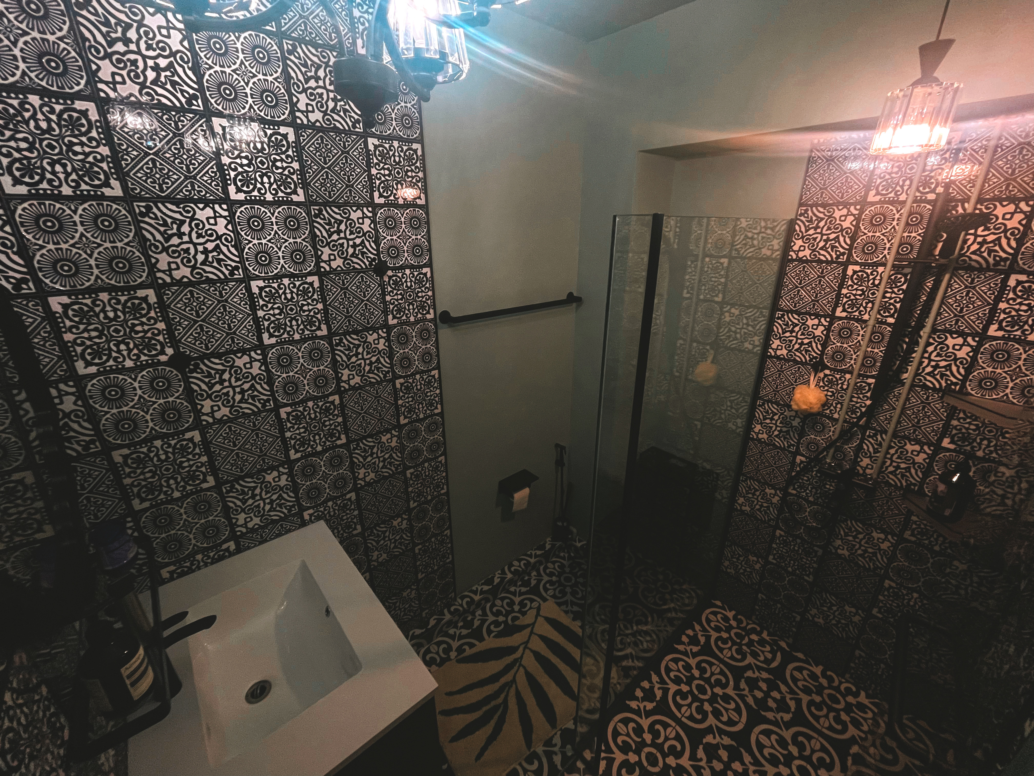 A unique blend of mid-century charm & cottage coziness - Patterned tiles, ornate chandelier, black and white design