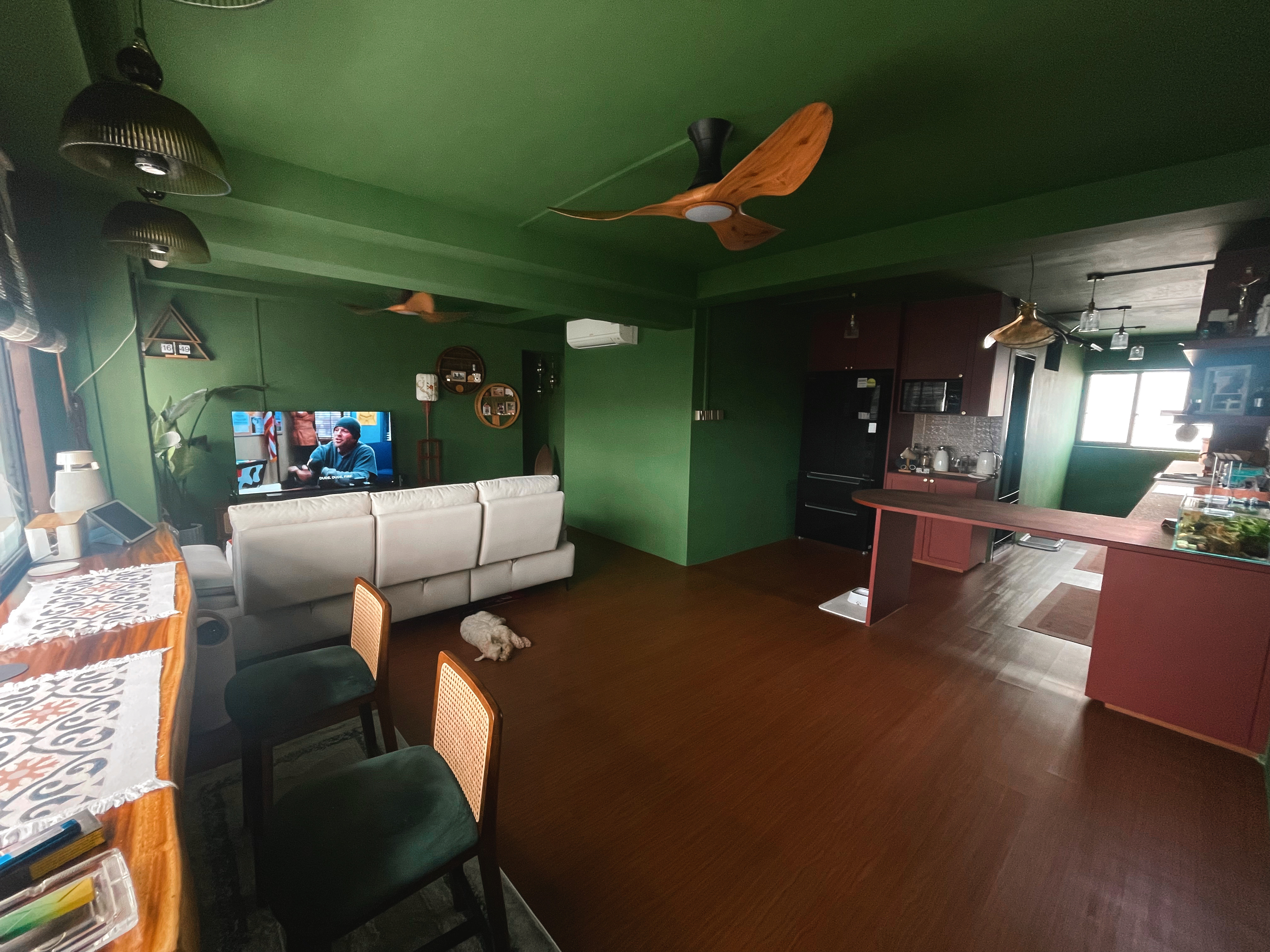 A unique blend of mid-century charm & cottage coziness - Green walls, modern ceiling fan, white leather sofa, wooden floor