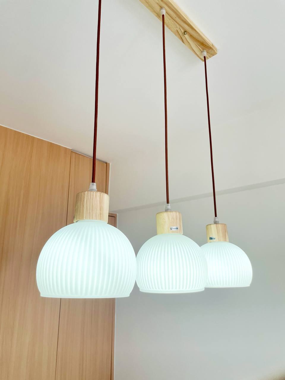 A Japandi Home with a Blue Heart under $30k - Modern pendant lights with wooden accents, white ribbed glass shades, wooden