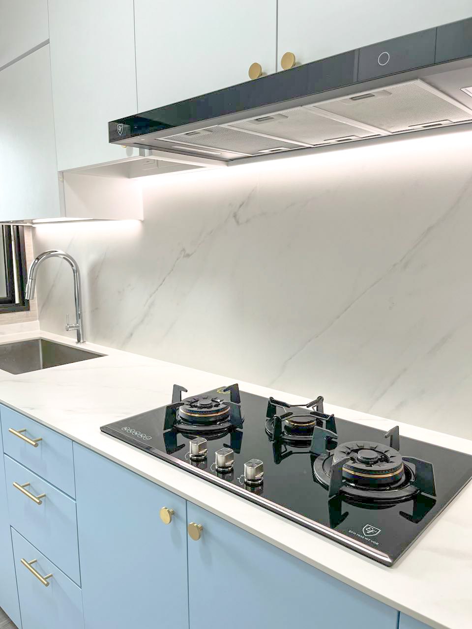 A Japandi Home with a Blue Heart under $30k - Modern kitchen with sleek black gas stove, white marble countertop, light blue