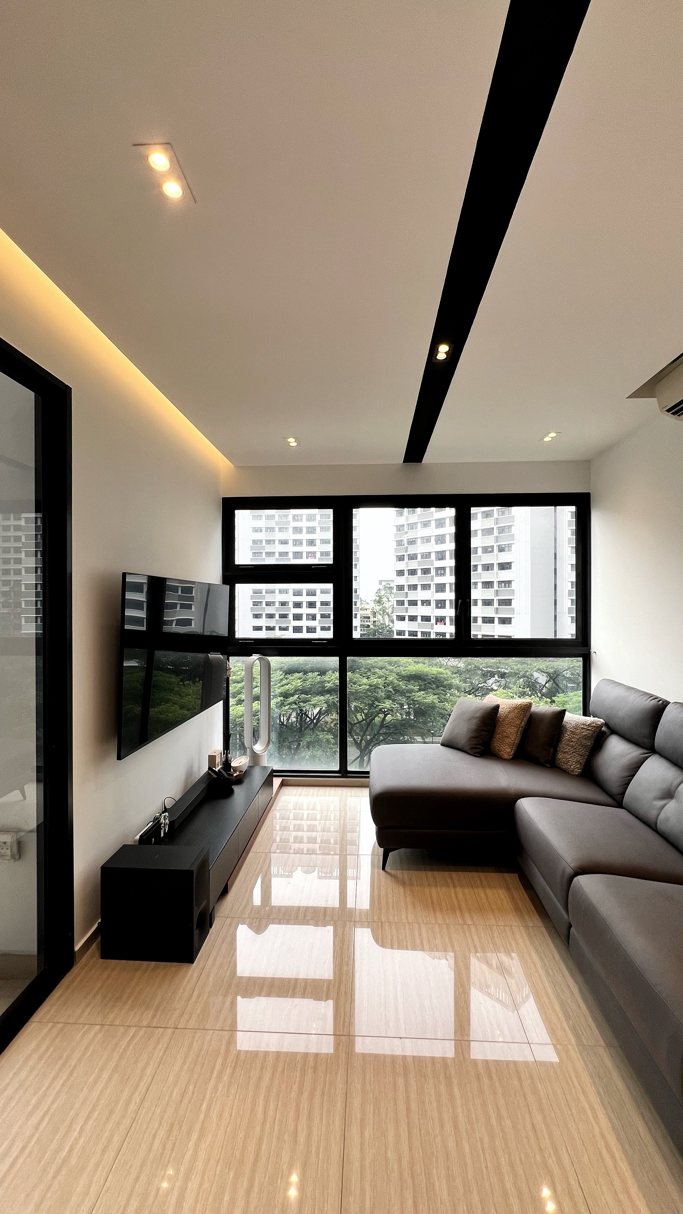 Our little cosmopolitan treehouse! - Modern living room with large windows, sleek black entertainment unit, minimalist
