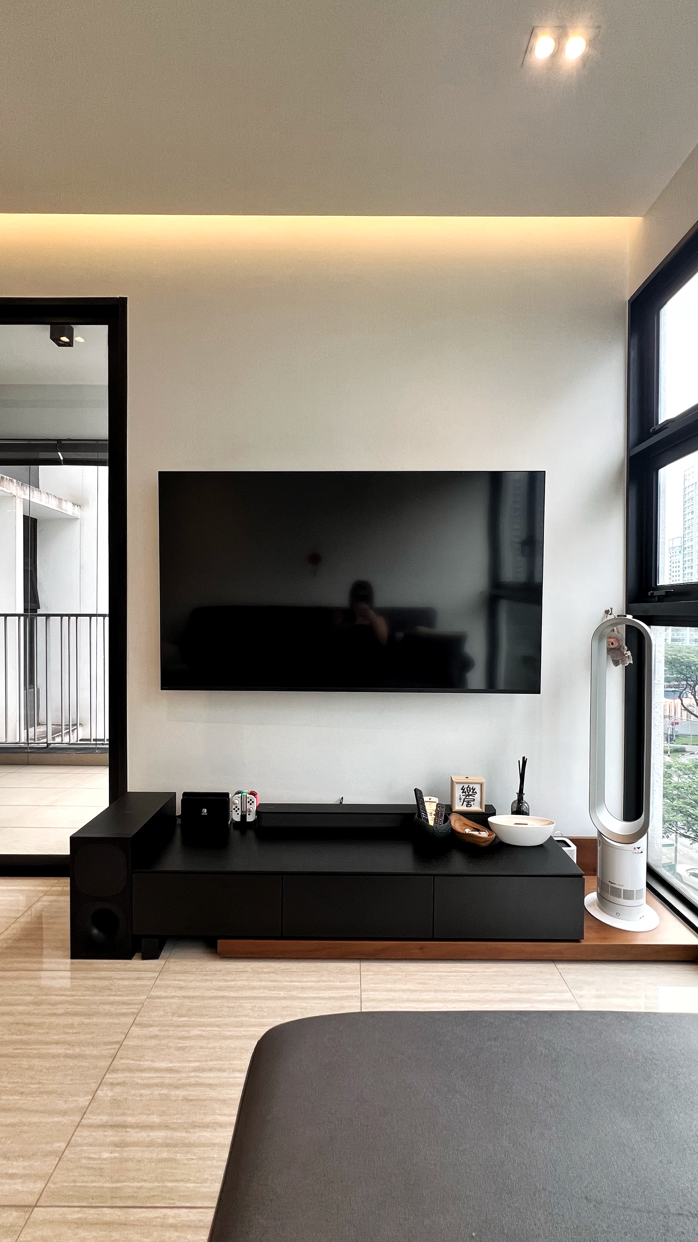 Our little cosmopolitan treehouse! - modern living room, sleek entertainment center, black TV stand, minimalist decor, large
