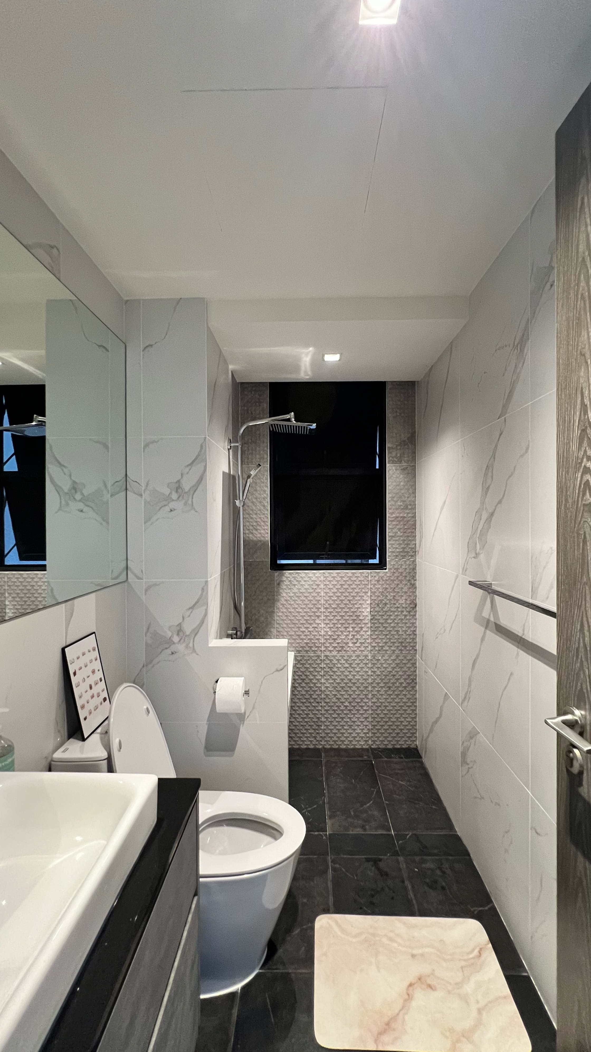 Our little cosmopolitan treehouse! - Modern bathroom with sleek design, white marble tiles, black and white color scheme